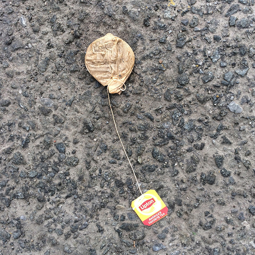 A photo of lost or discarded material found on a city street—with a form interpreted as resembling a balloon.