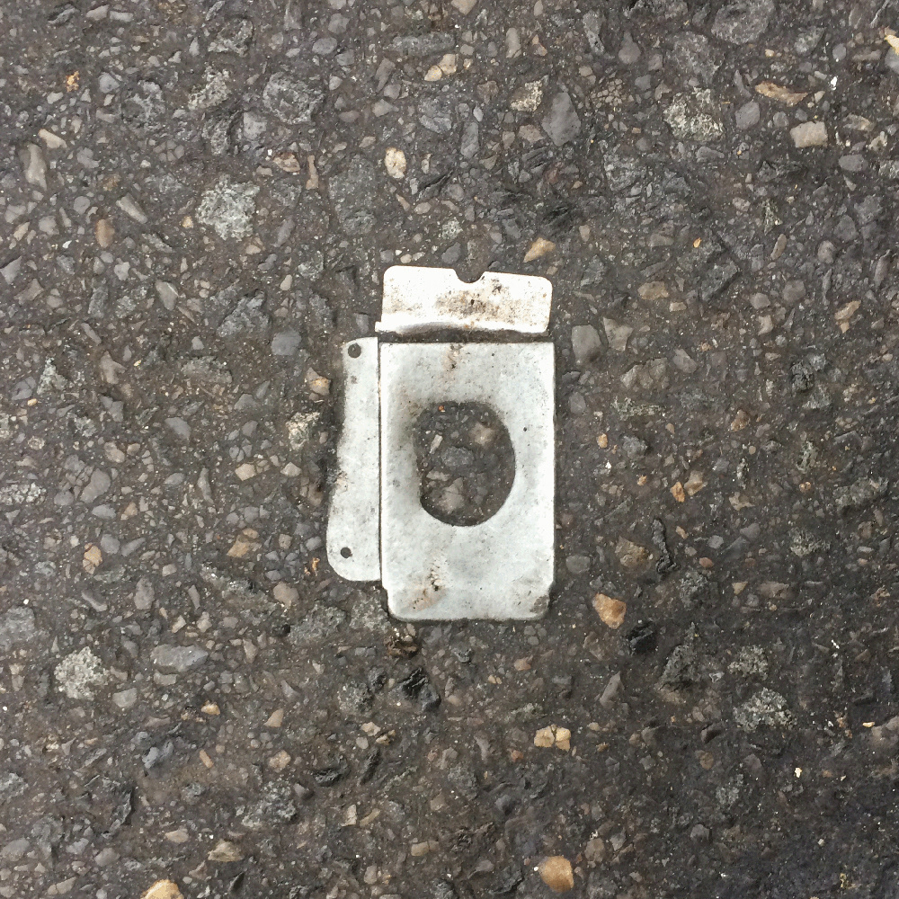 A photo of lost or discarded material found on a city street—with a form interpreted as resembling a washing machine.