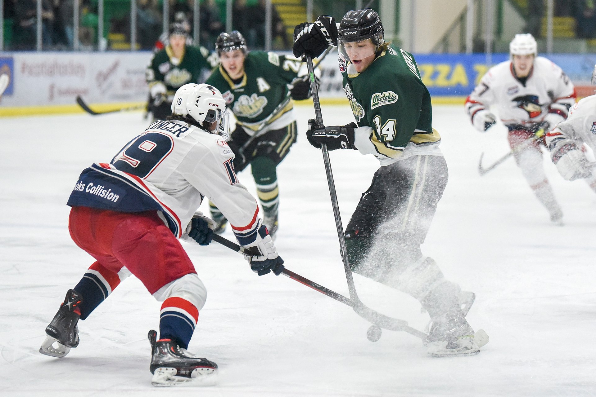 Okotoks Oilers forward Rieger Lorenz carries the puck against defenceman Joshua Zinger of the Brooks Bandits during game four of the AJHL South Finals playoff series at the Pason Centennial Arena in Okotoks on April 13, 2022.