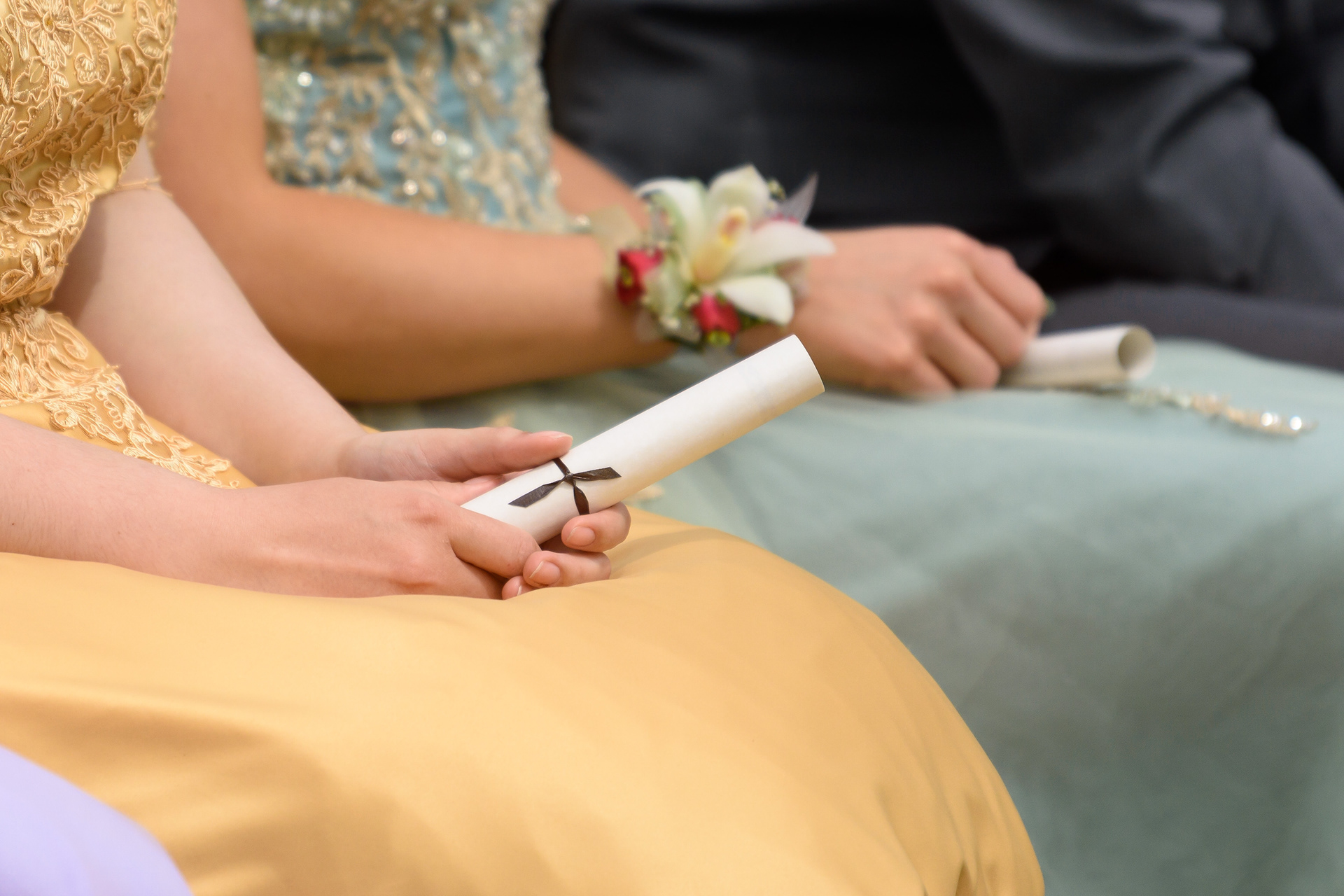 Graduating students of Oilfields High School hold onto their partchments during their graduation ceremony in Black Diamond on June 3, 2022.