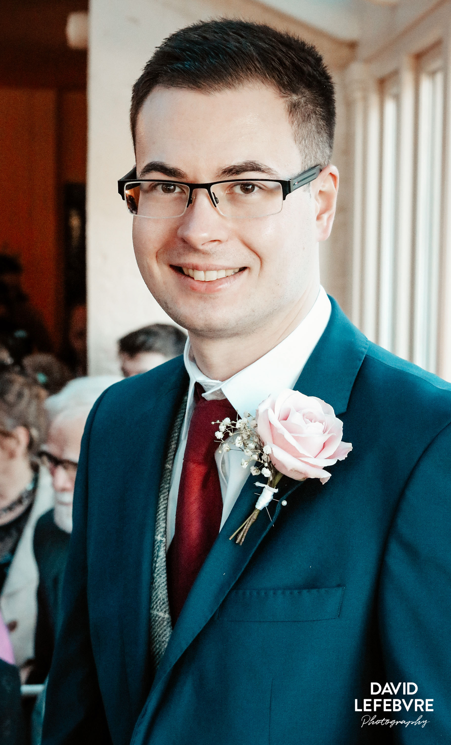 groomsmen smiling in suit with rose