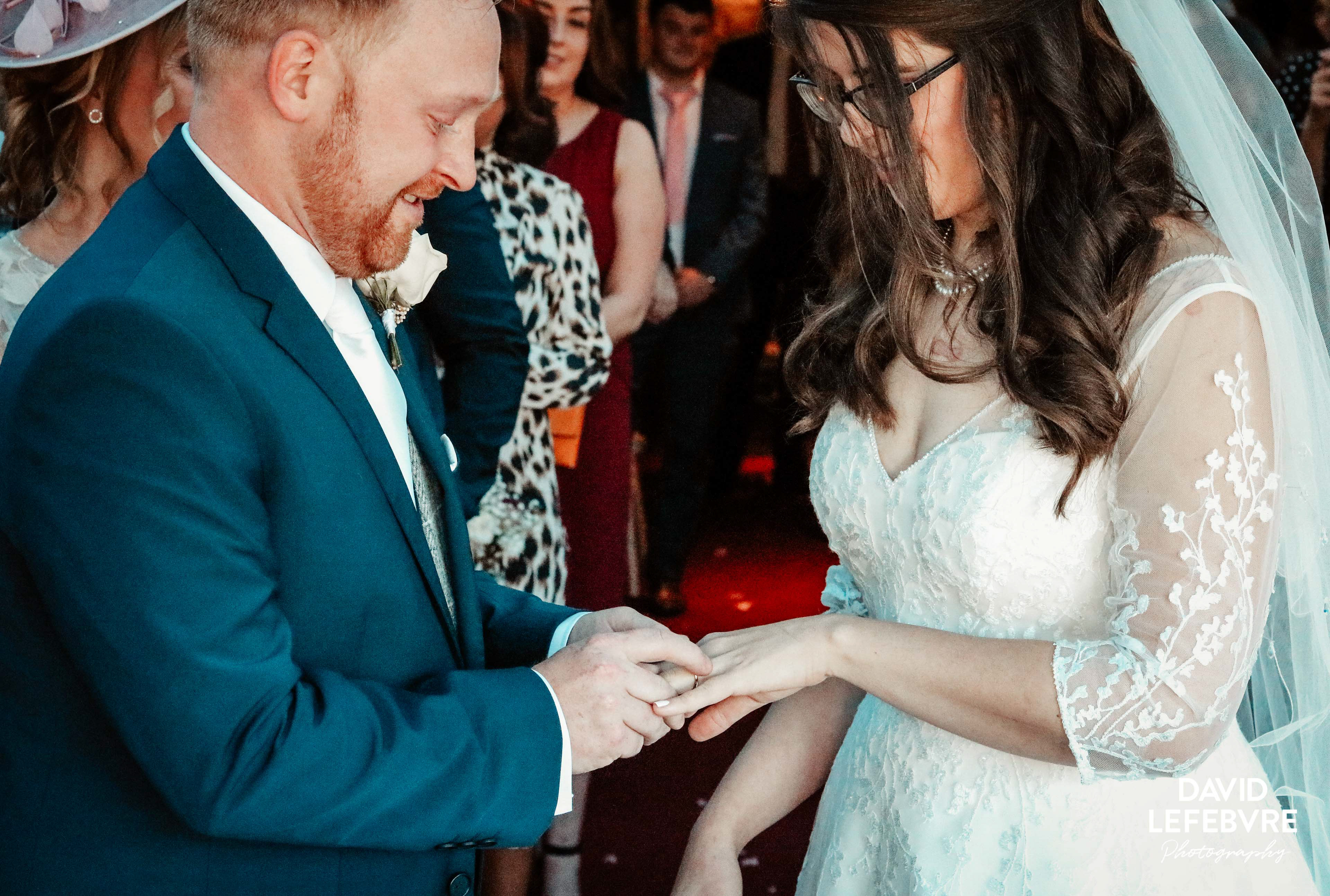 groom placing ring on brides hand at hotel