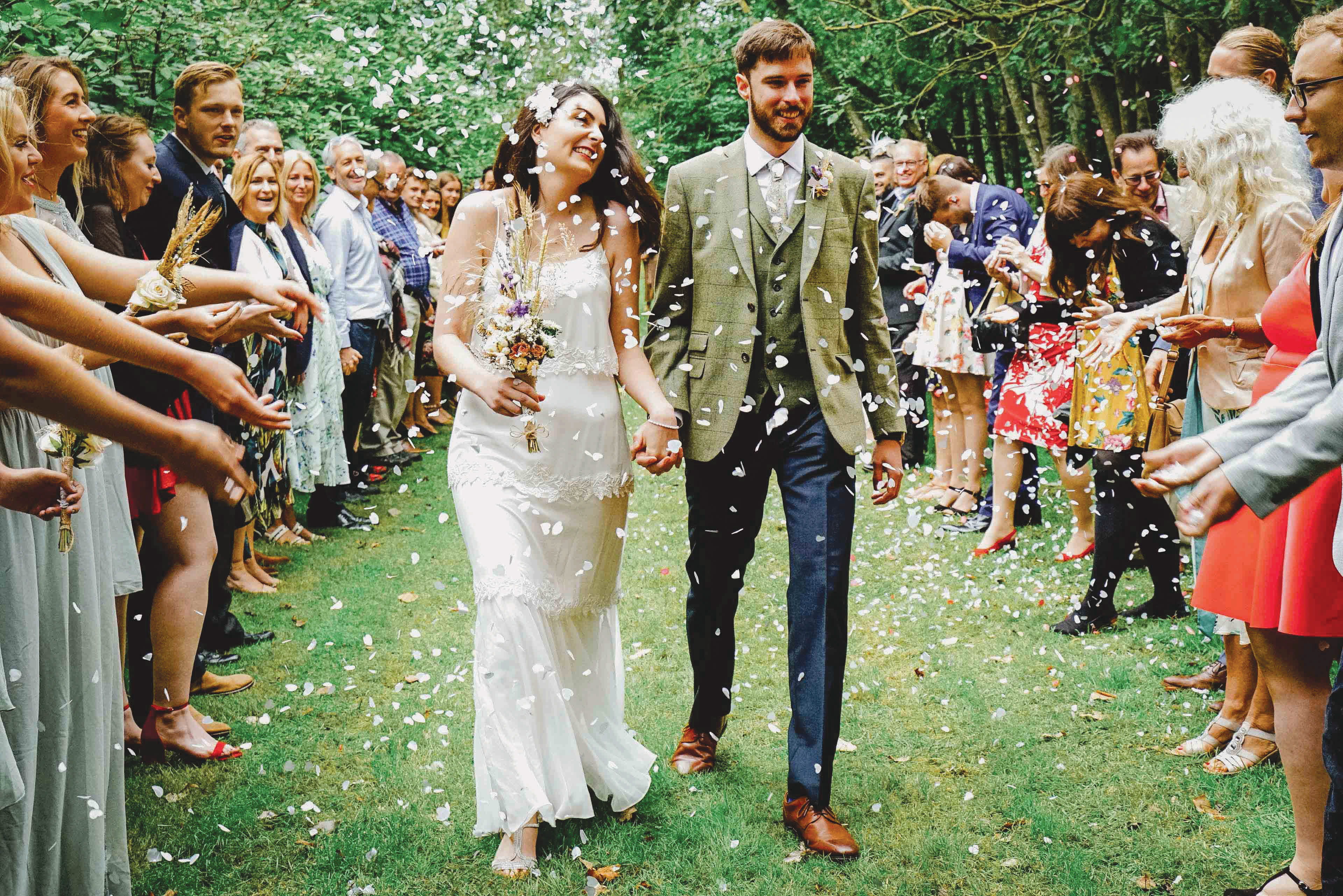 the top 10 essential wedding photos image of confetti and exit shot of smiling couple surrounded by friends and family at candid countryside wedding in swanbourne taken by david lefebvre