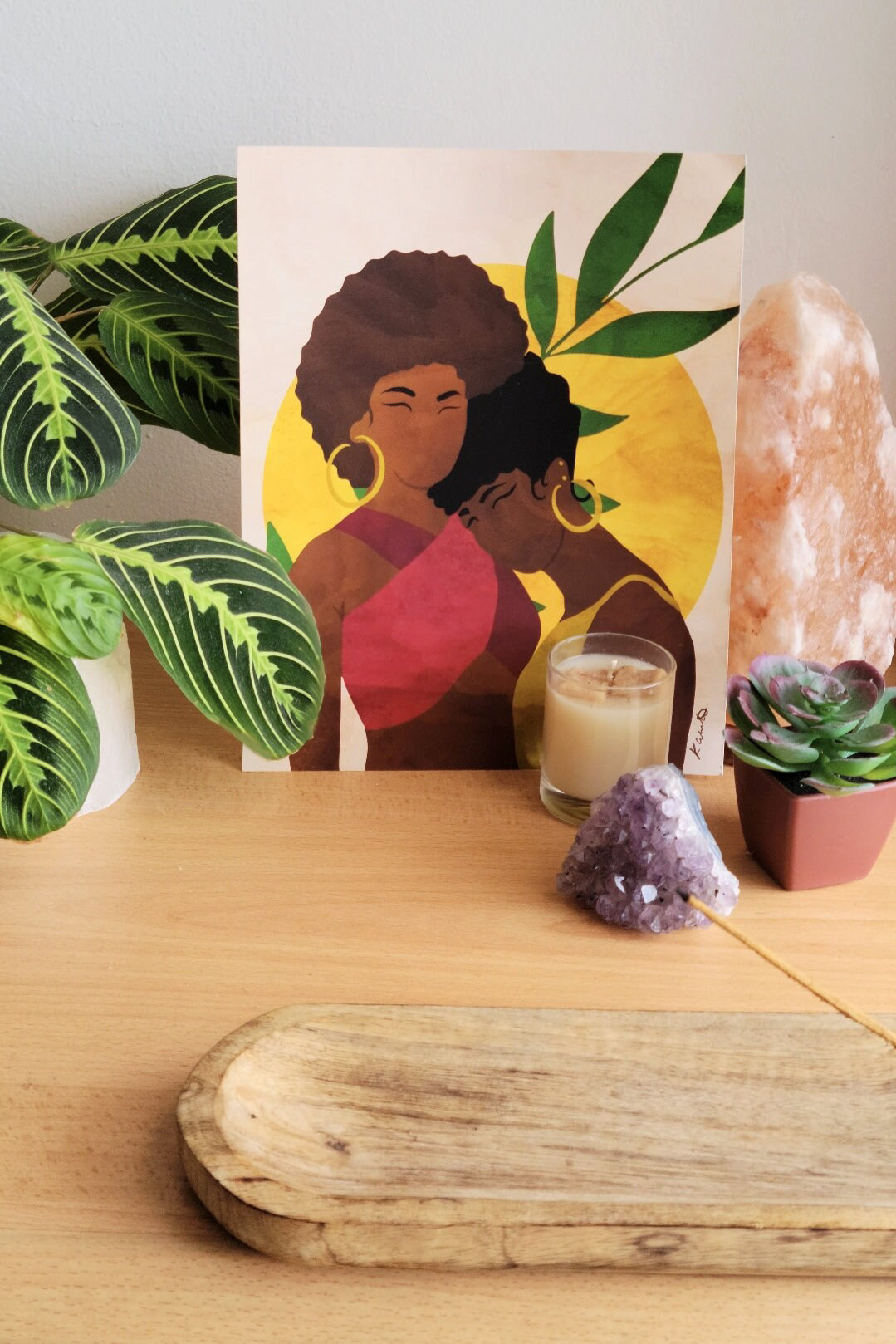 Table setup featuring the "My Sister's Keeper" art print amongst relaxing decor, crystals, and plants.