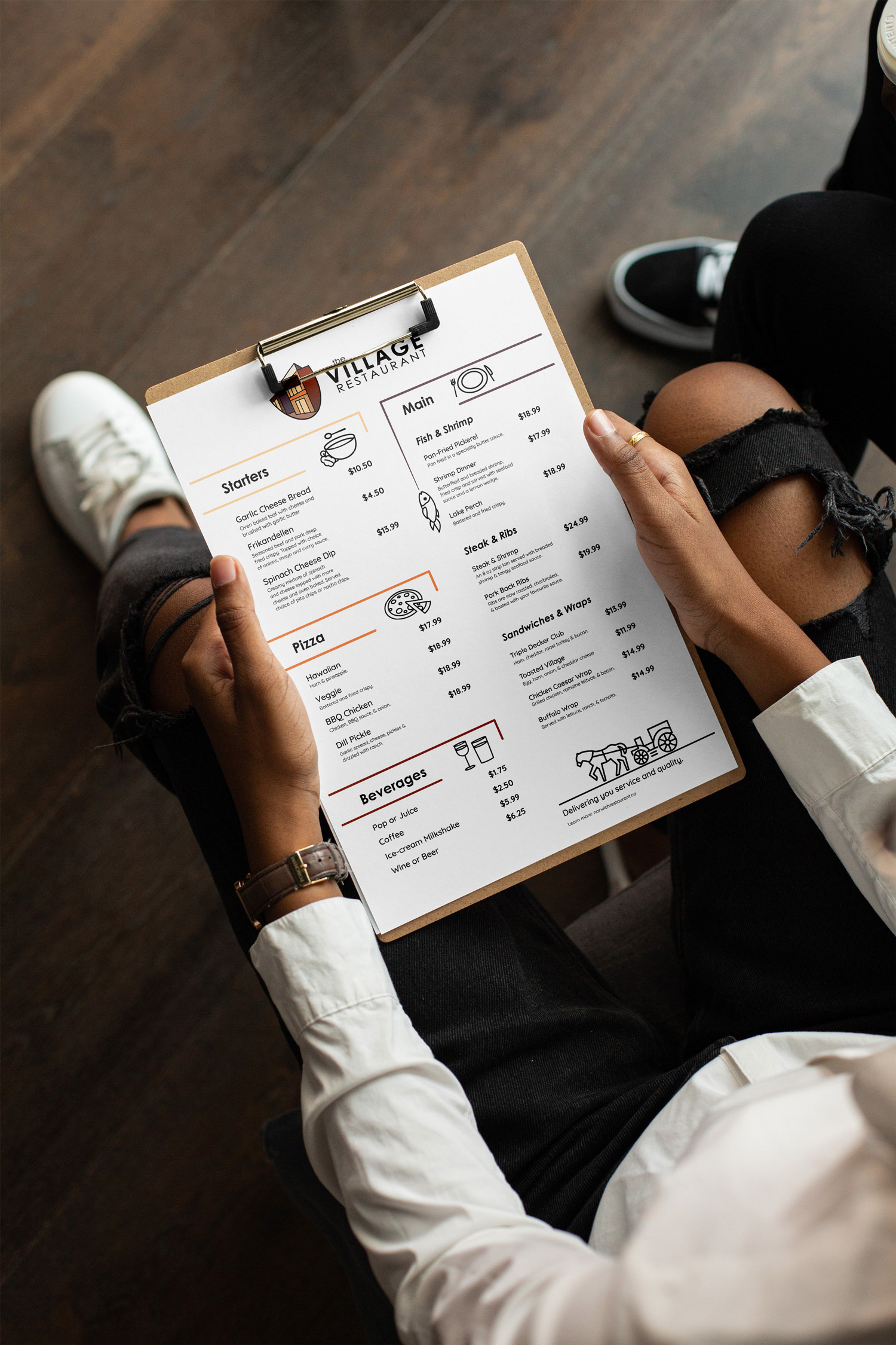 The Village Restaurant menu on a clip board being held by a person