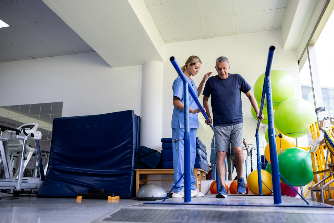 Woman assisting elder with physiotherapy