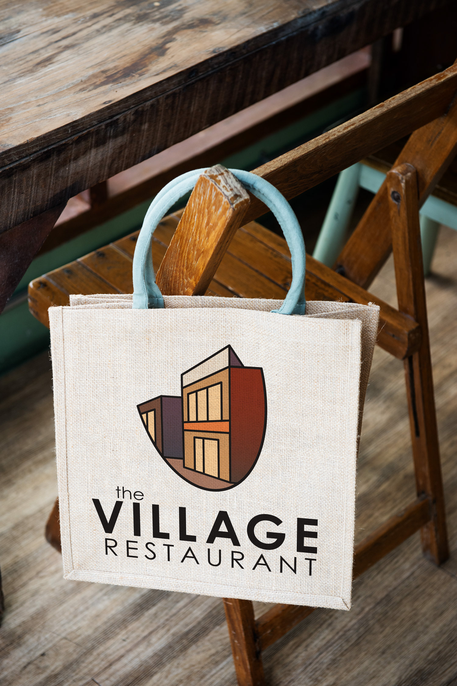 The Village Restaurant Logo on a bag