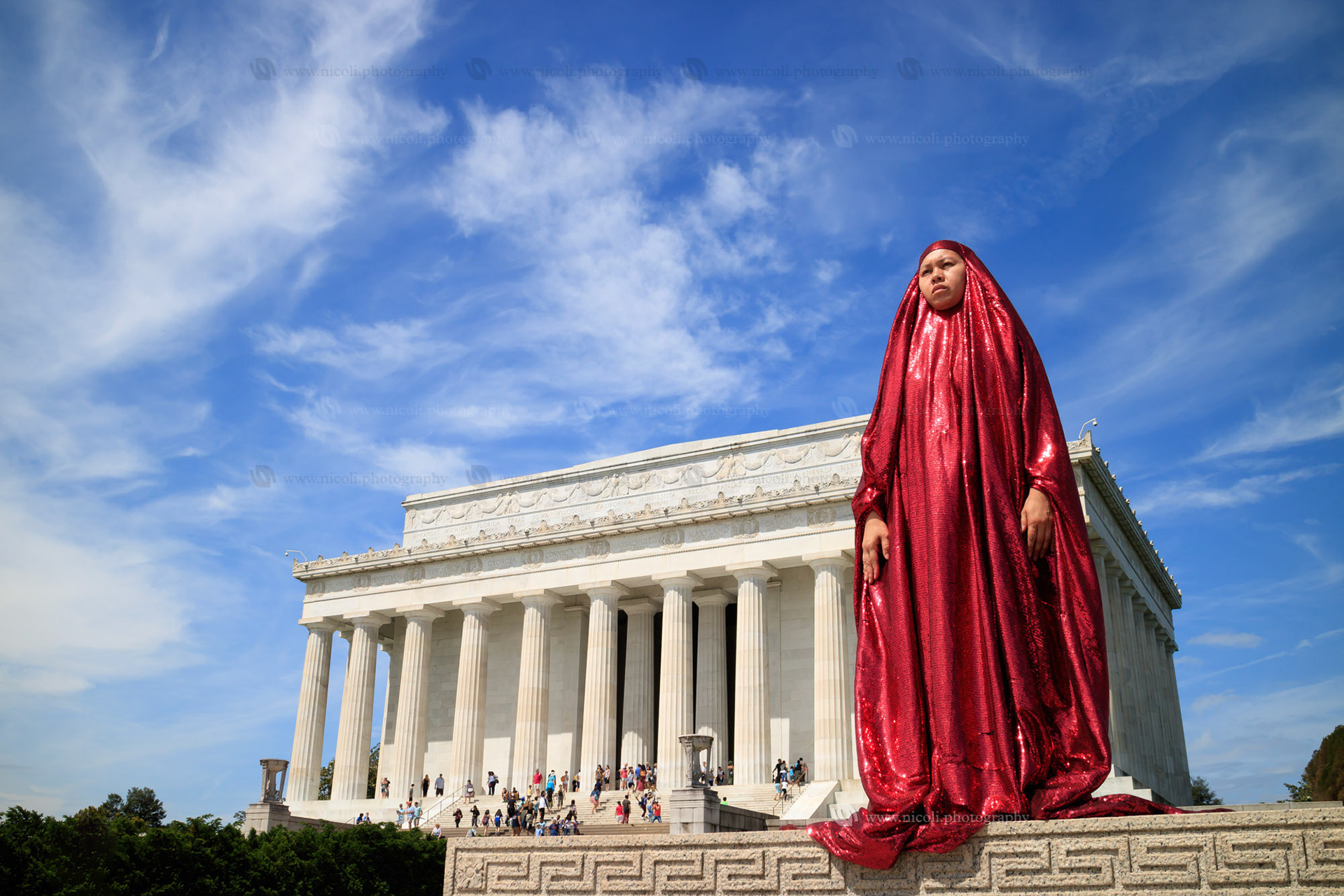 Washington DC, USA - May 28, 2016: Tourists visiting the Lincoln Memorial at the National Mall in Washington DC. A woman in red pose in front.