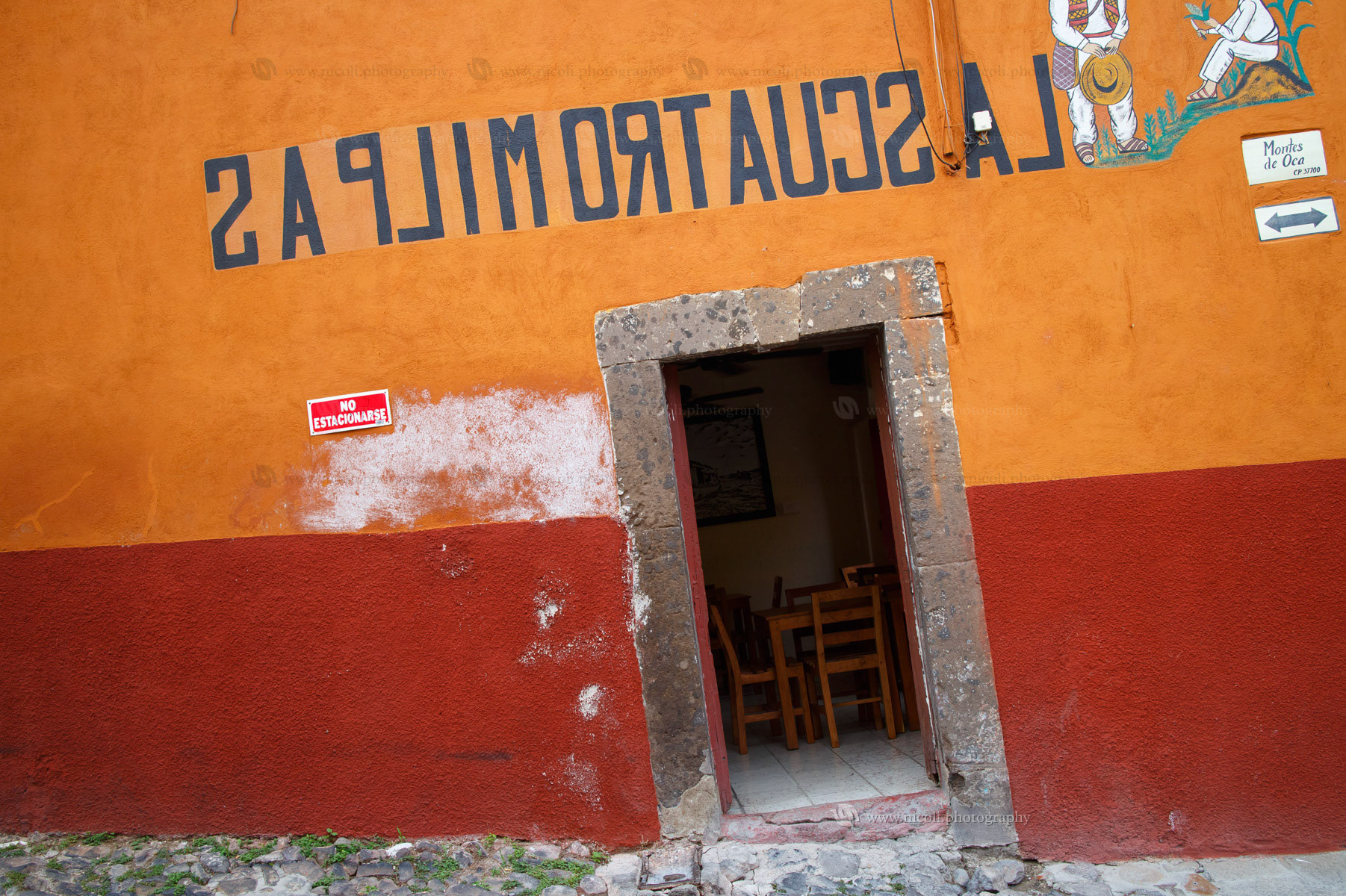 SAN MIGUEL DE ALLENDE, GUANAJUATO, MEXICO -  MAY, 29, 2014: Detail of a house in the historic town of San Miguel de Allende with an inverted text that reads "the four cornfields". San Miguel de Allende, Guanajuato, Mexico on May, 29, 2014.