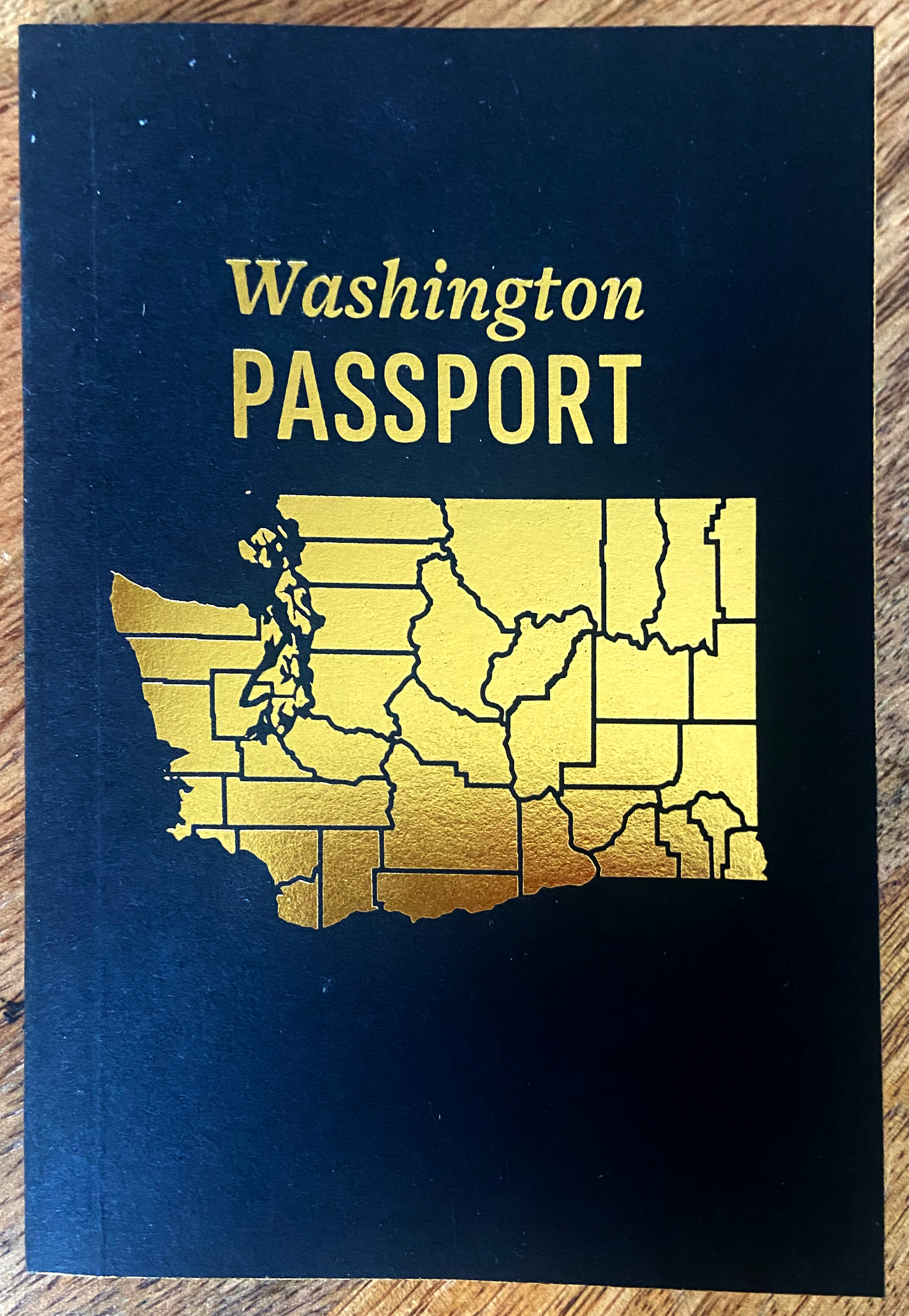 Washington State passport with gold counties outlined on the cover
