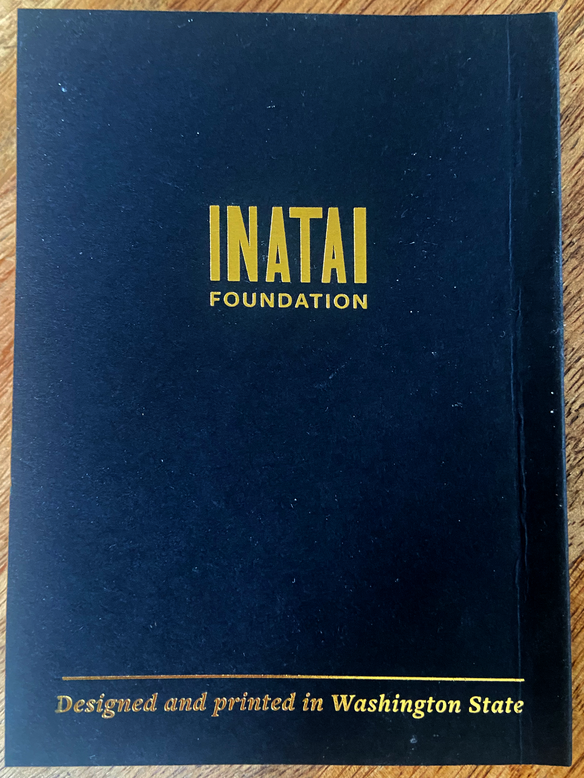 Back of Washington State passport featuring Inatai Foundation logo in gold