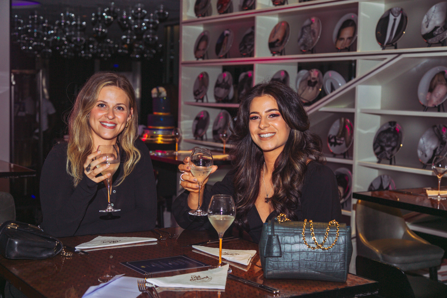 Two friends enjoying a drink with big smiles on their faces 