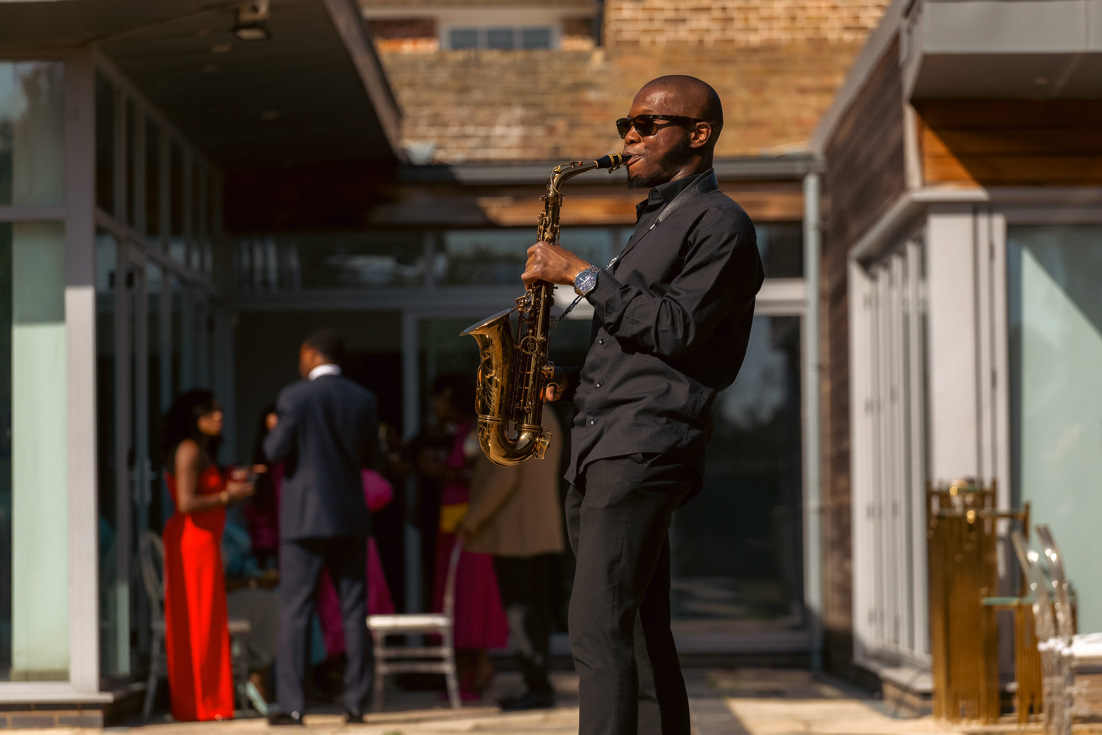 A gentleman playing on a sax to set them mood at the birthday event 
