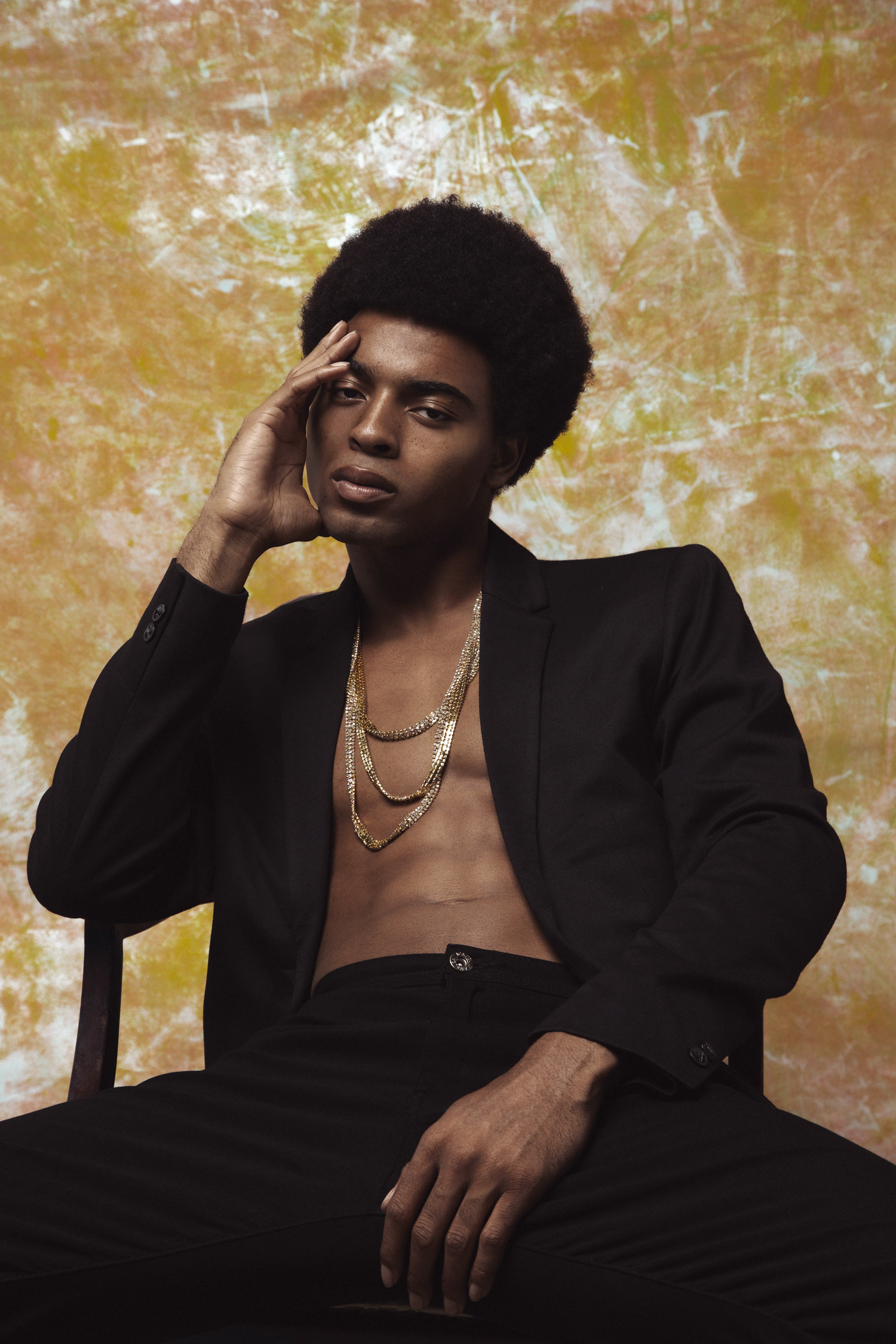 A stunning background of a yellow and orange backdrop with a male model in the frame wearing a blazer for a fashion project