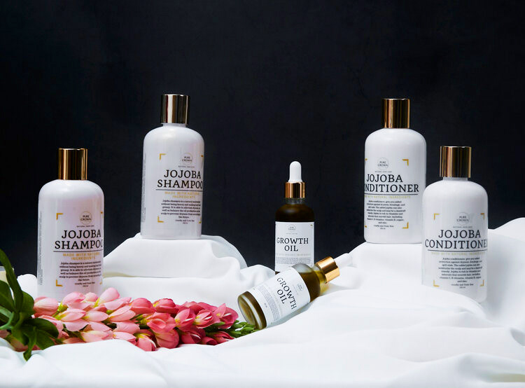 Haircare products on a table covered with a white cloth for lifestyle shoot