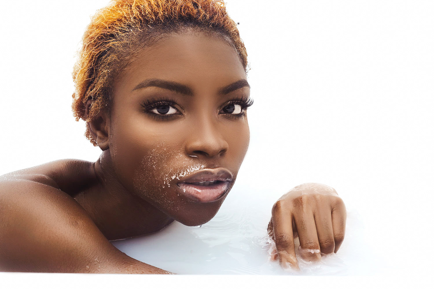 Model Wura posing confidently in a milk bath, captured for a creative photography project.