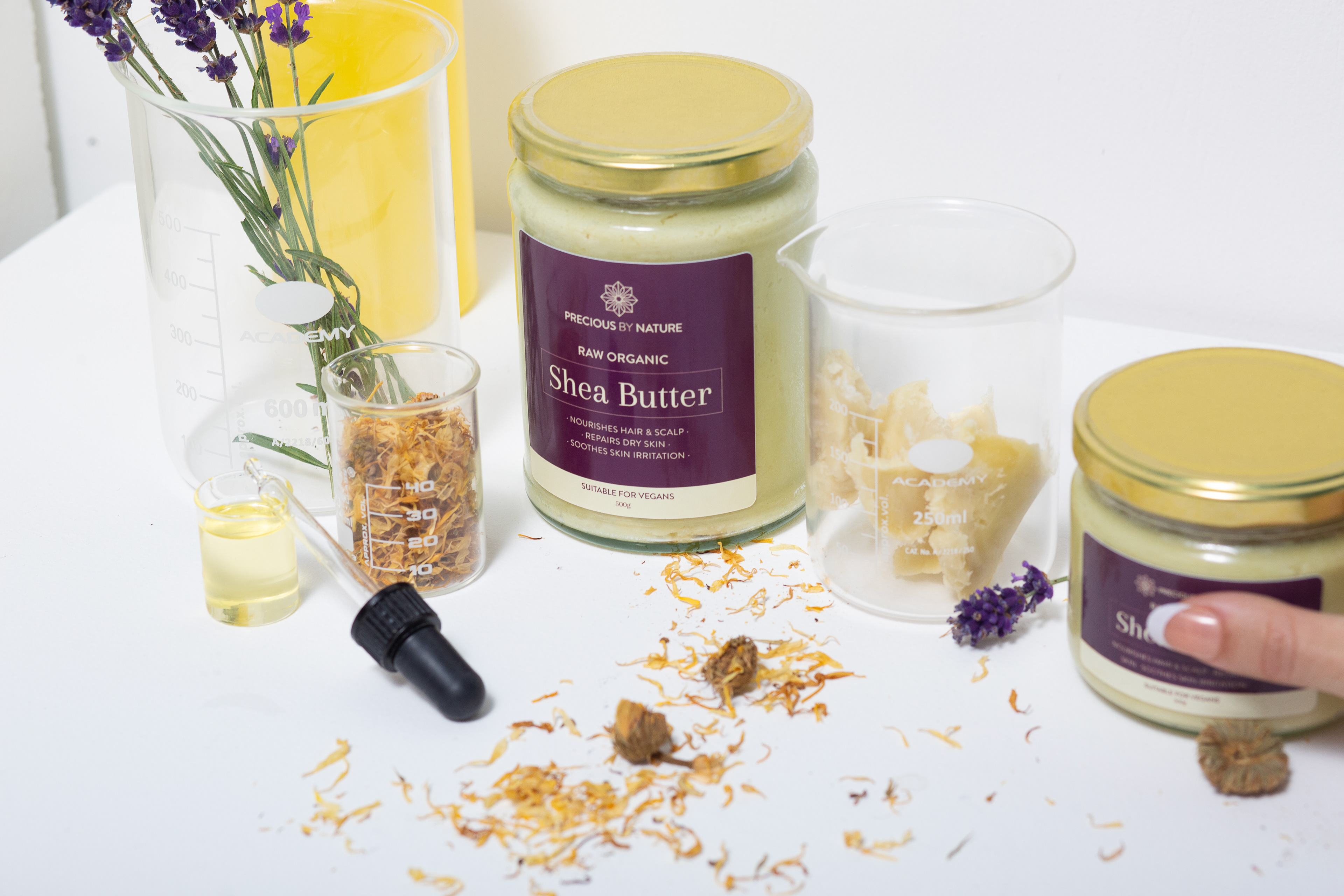Jars of shea butter on a table with lavender 