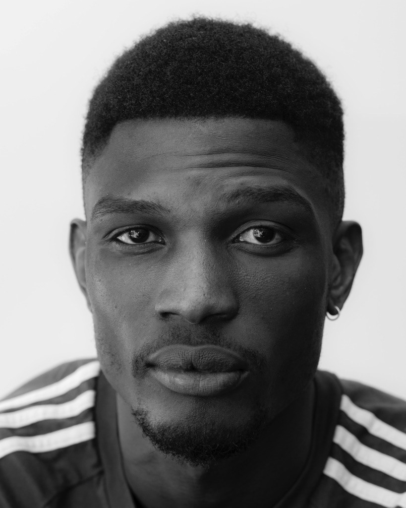 black and white headshot shot with natural light with a bit of a shadow on the right side of the face to create mystery