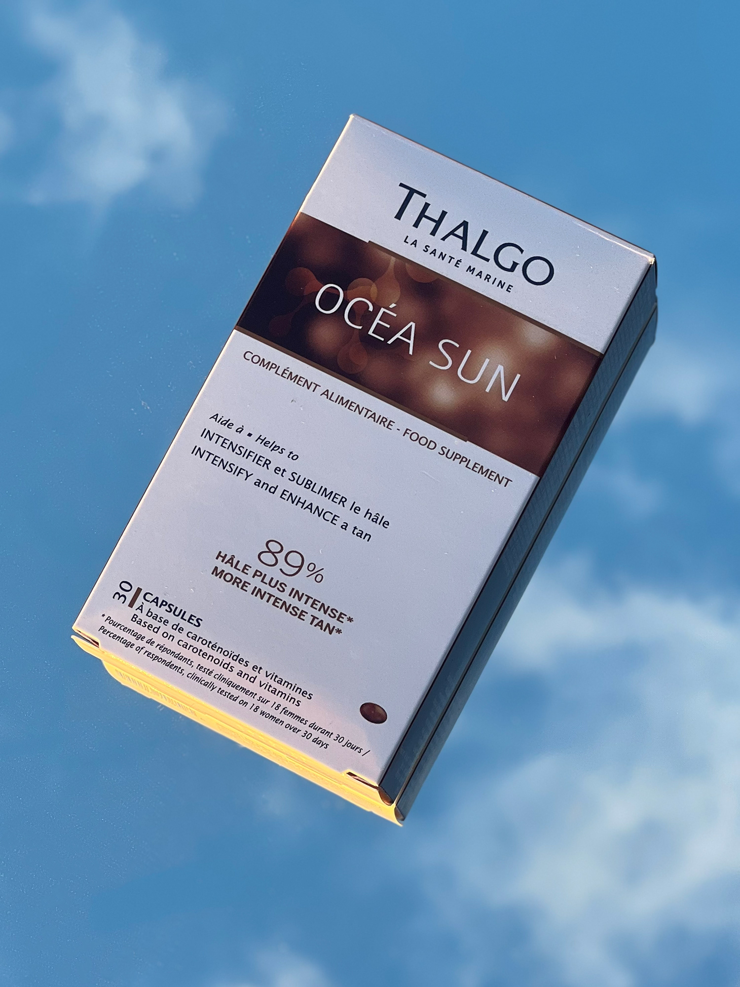 Summertime product from thalgo uk shot with a mirror in natural light with the sky as the background