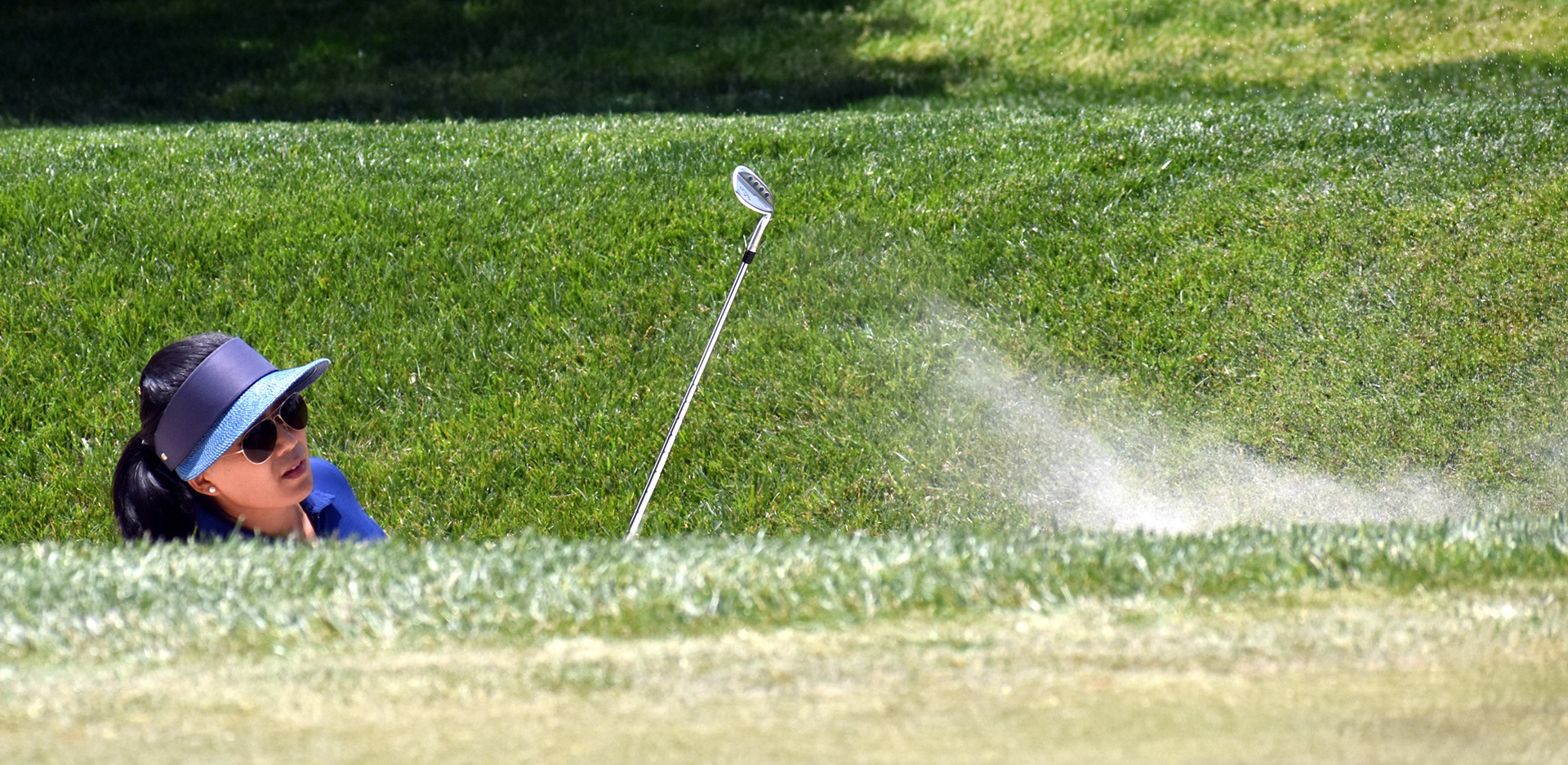 Jenny Suh Thompson goes deep to escape the greenside bunker on 5. She'd get out to within three feet and tap in for par.
