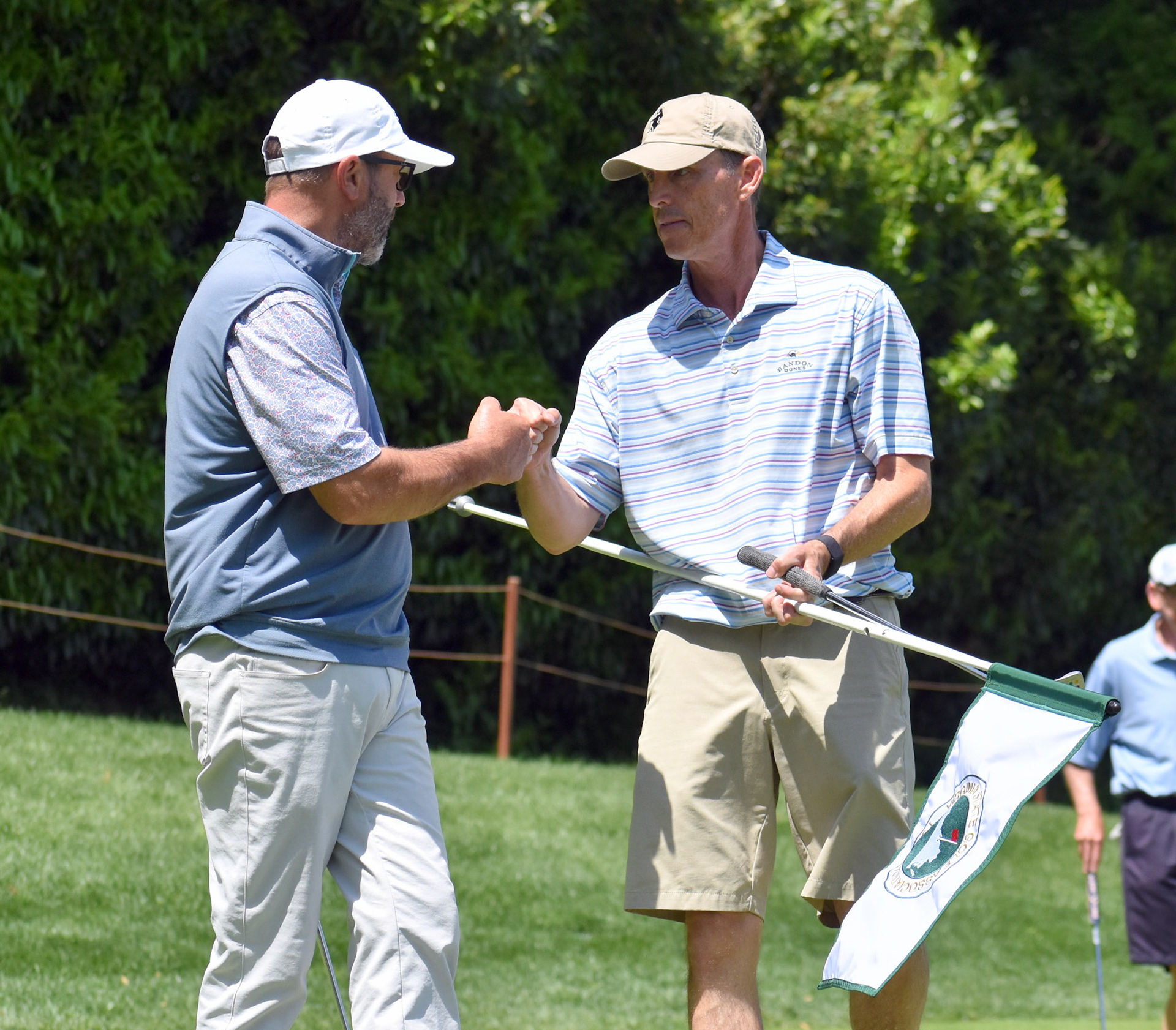 Rick Peel and Scott Shingler celebrate after Peel drained a birdie putt on 12.