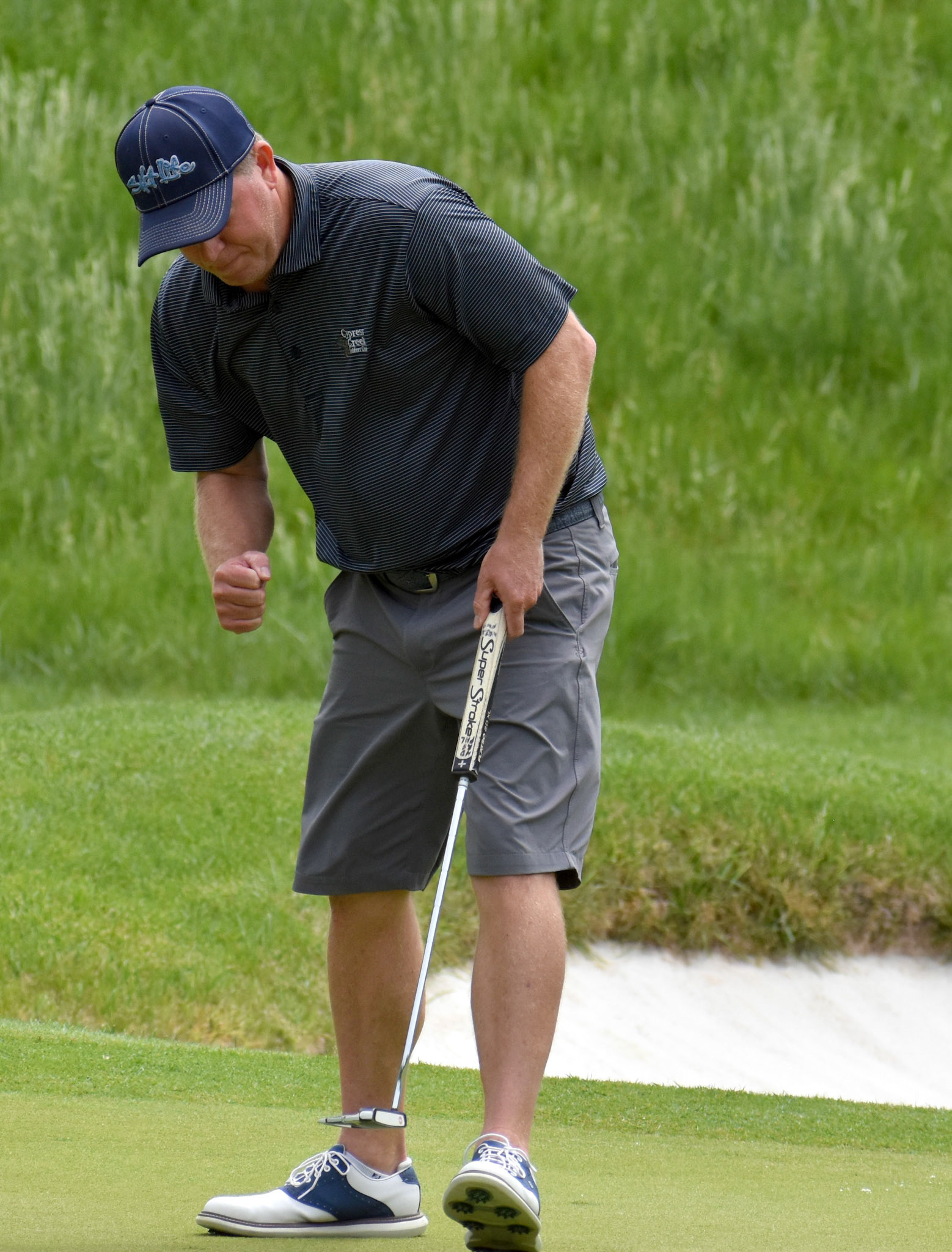 Jason Dunn pumps his fist as his birdie putt on 14 drops.