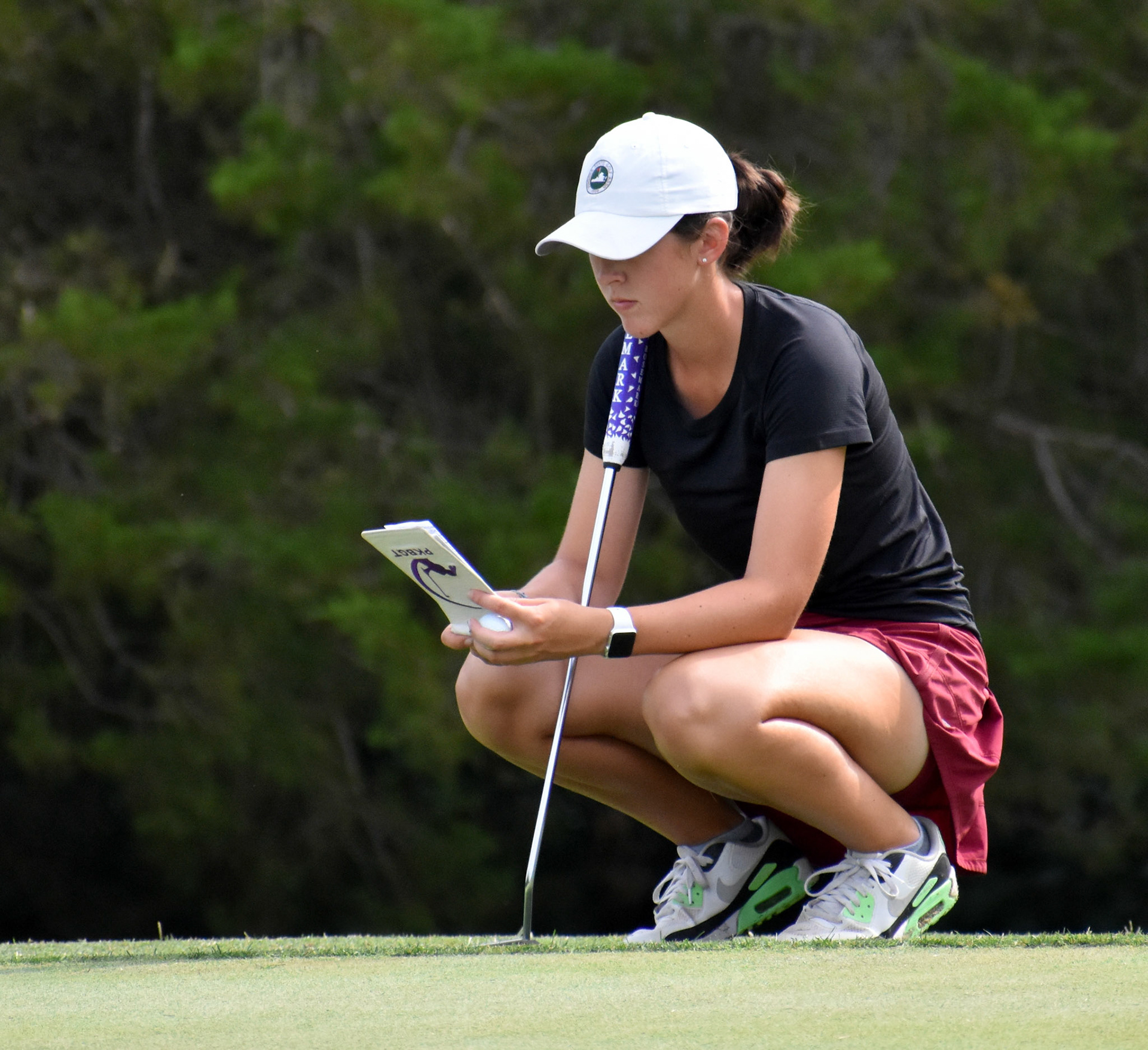 Amber Mackiewicz checks her notes before putting on 8 green
