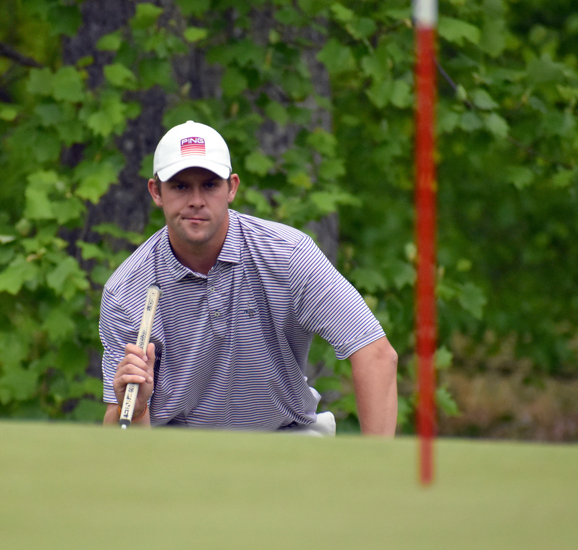 Drew Brockwell gets low to read his putting line on 11
