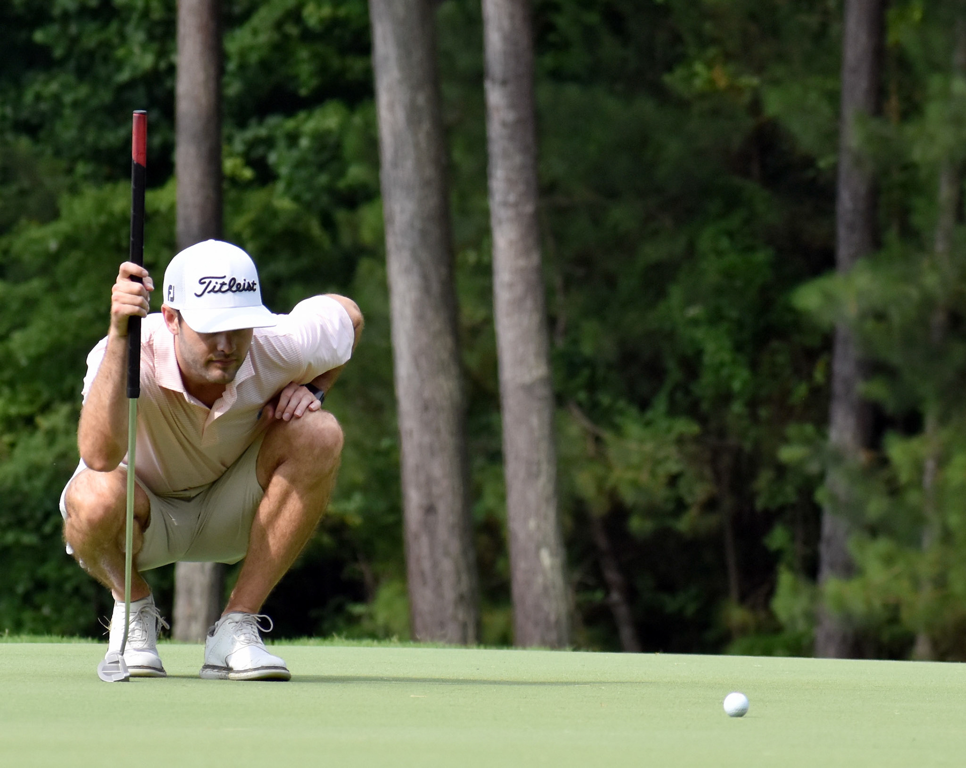 Evan Beck eyes his putting line on 16