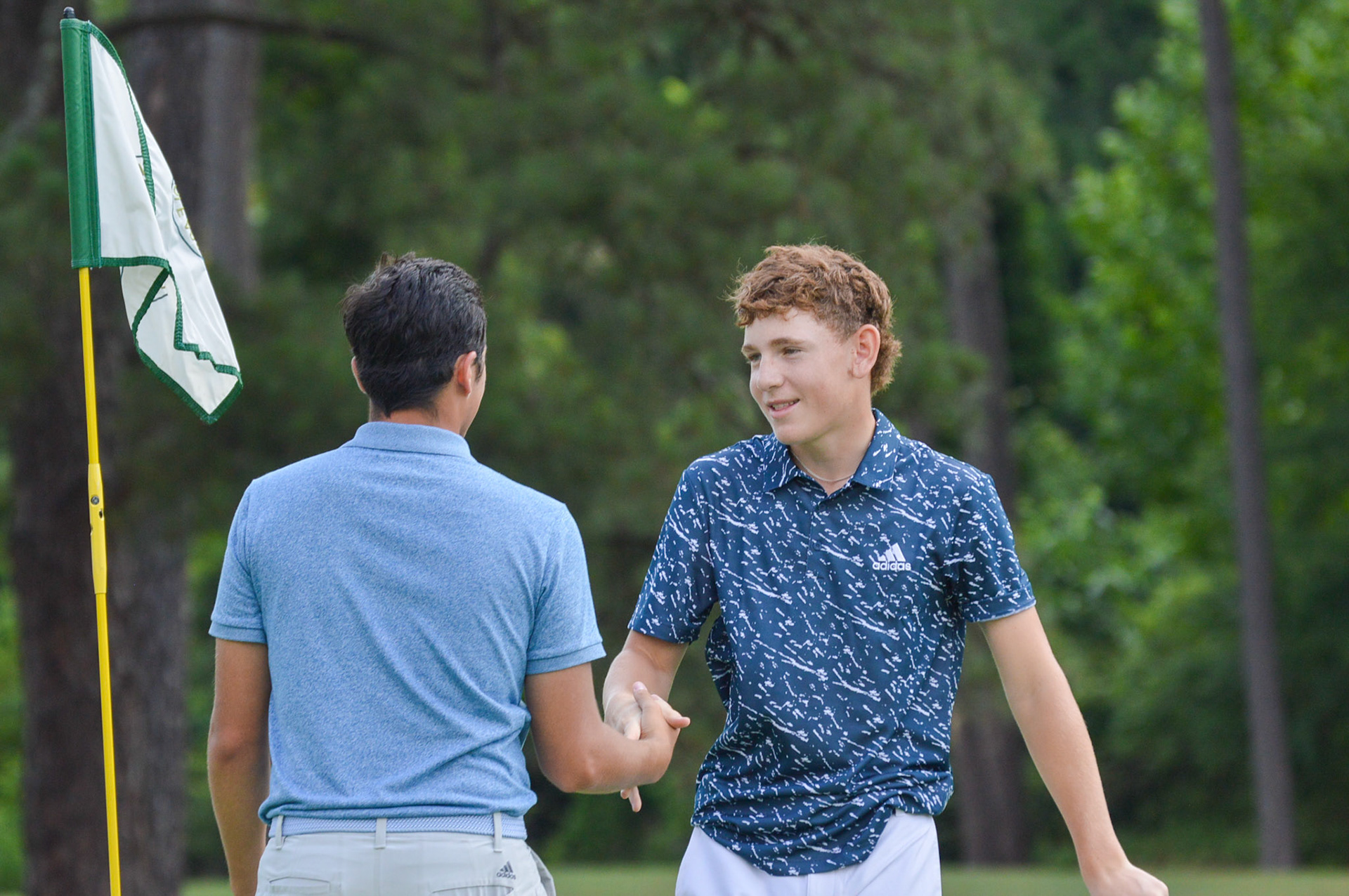 Wood's caddy, Jake, shakes hands with Reilly