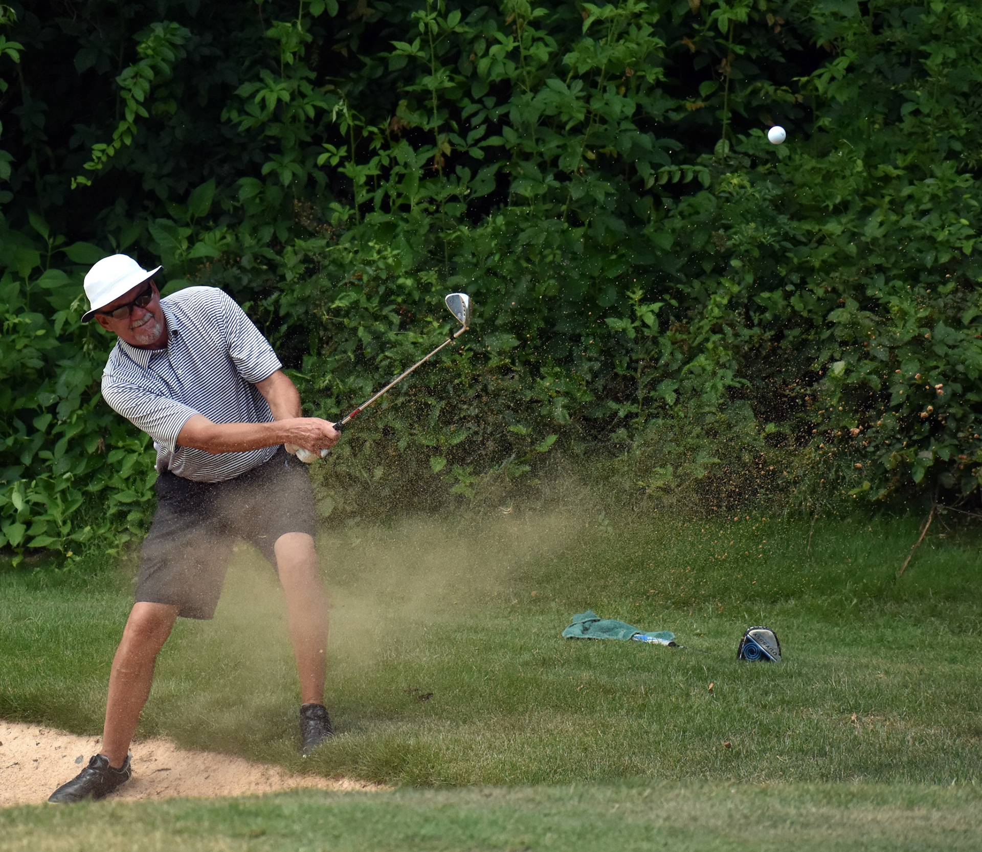 Dean Griffith deals with an awkward stance hitting out of the bunker on 12.