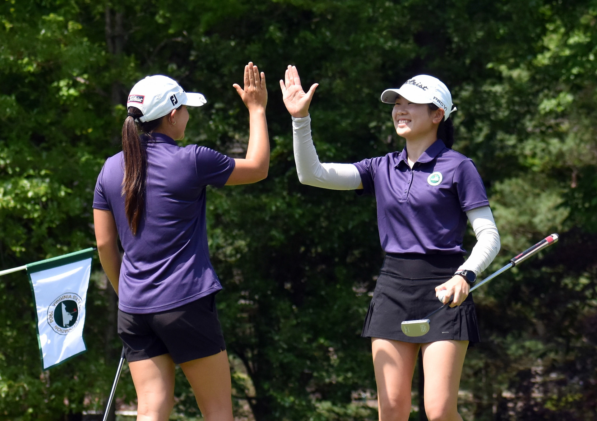 Sydney Hackett and Julie Shin celebrate after Shin dropped a short birdie putt on 11.