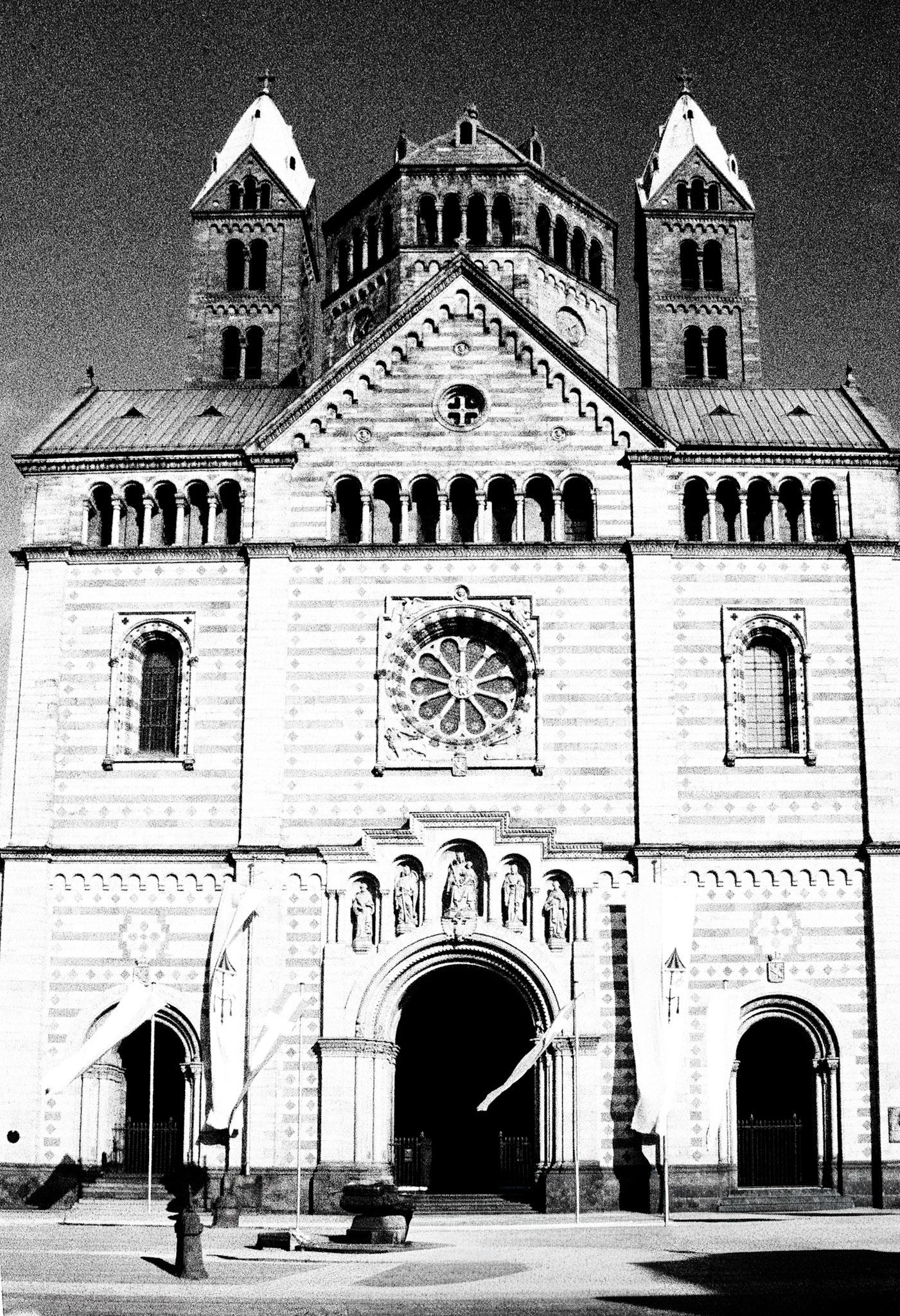 The monumental Romanesque façade of Speyer Cathedral, its striped sandstone and twin towers dominating the square.
