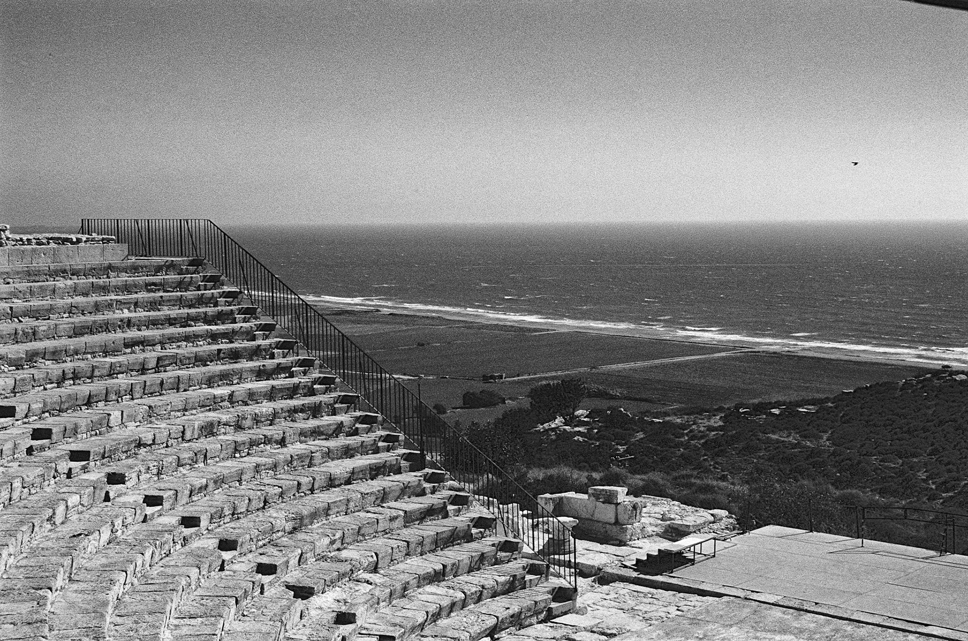 Kourion Ancient Theatre Ancient stone tiers descend toward a vast coastal plain and the shimmering Mediterranean beyond.