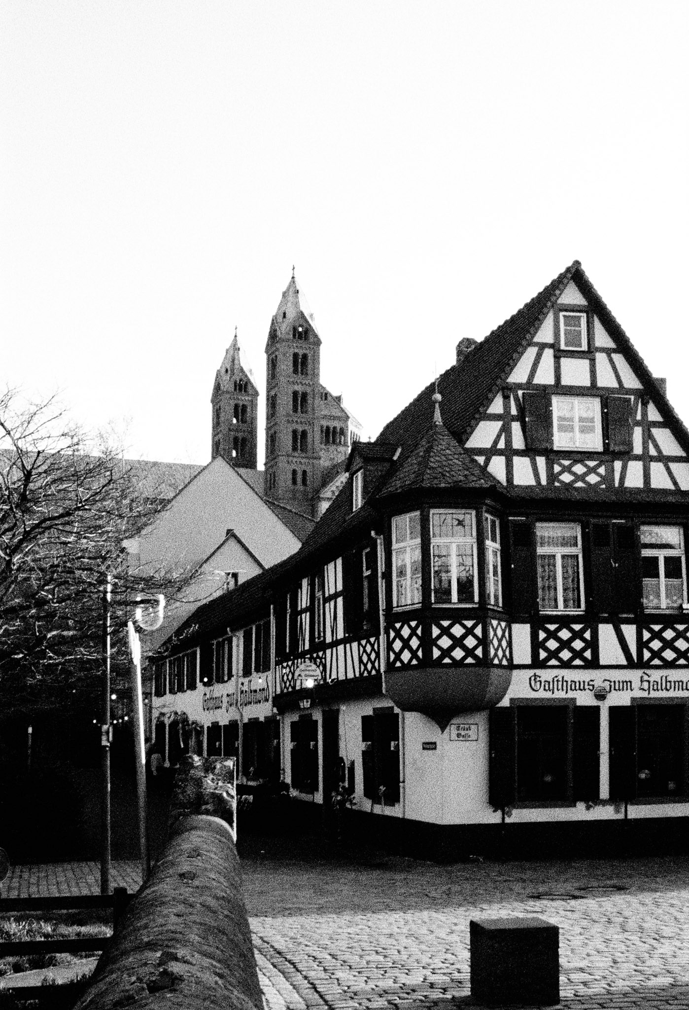 Half-timbered façades line the old town of Bad Wimpfen, with the Gasthaus zum Halbmond standing beneath the twin towers beyond.