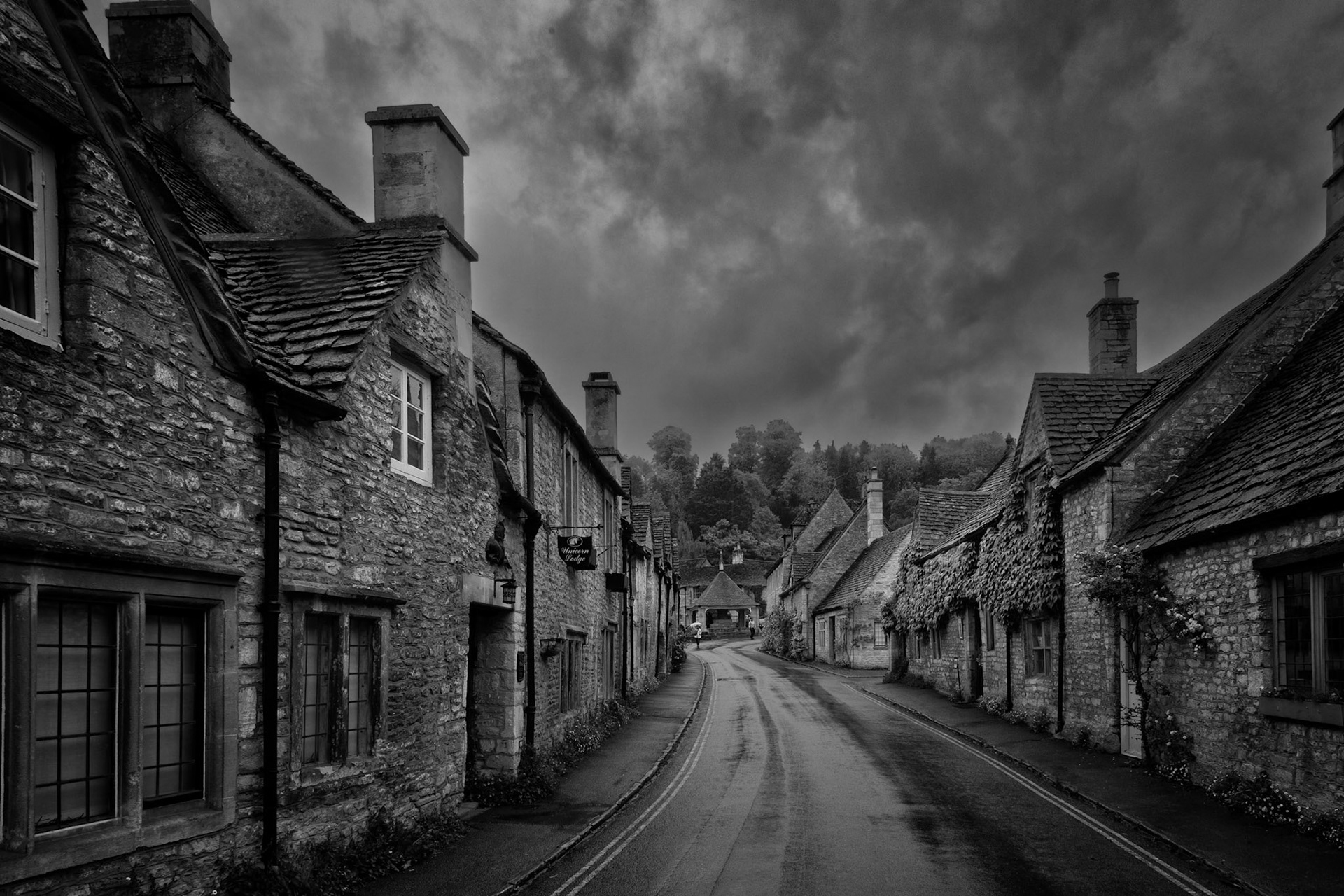 Castle Combe, often hailed as England’s prettiest village, reveals its timeless character in this quiet, rain-slicked scene. The winding road draws us through weathered stone cottages under a brooding sky, evoking centuries of unchanged calm. A perfect blend of texture, history, and light.