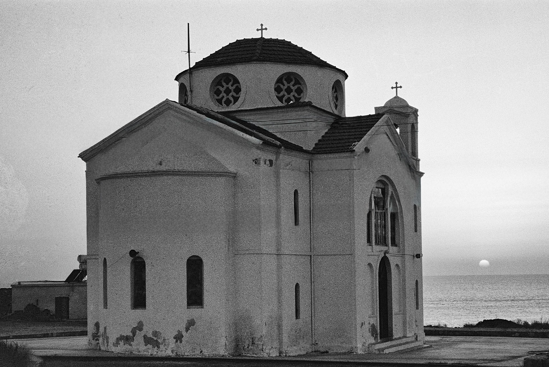 Agios Georgios (St George) A small Orthodox chapel stands quietly above the Mediterranean as the sun sinks into the horizon.