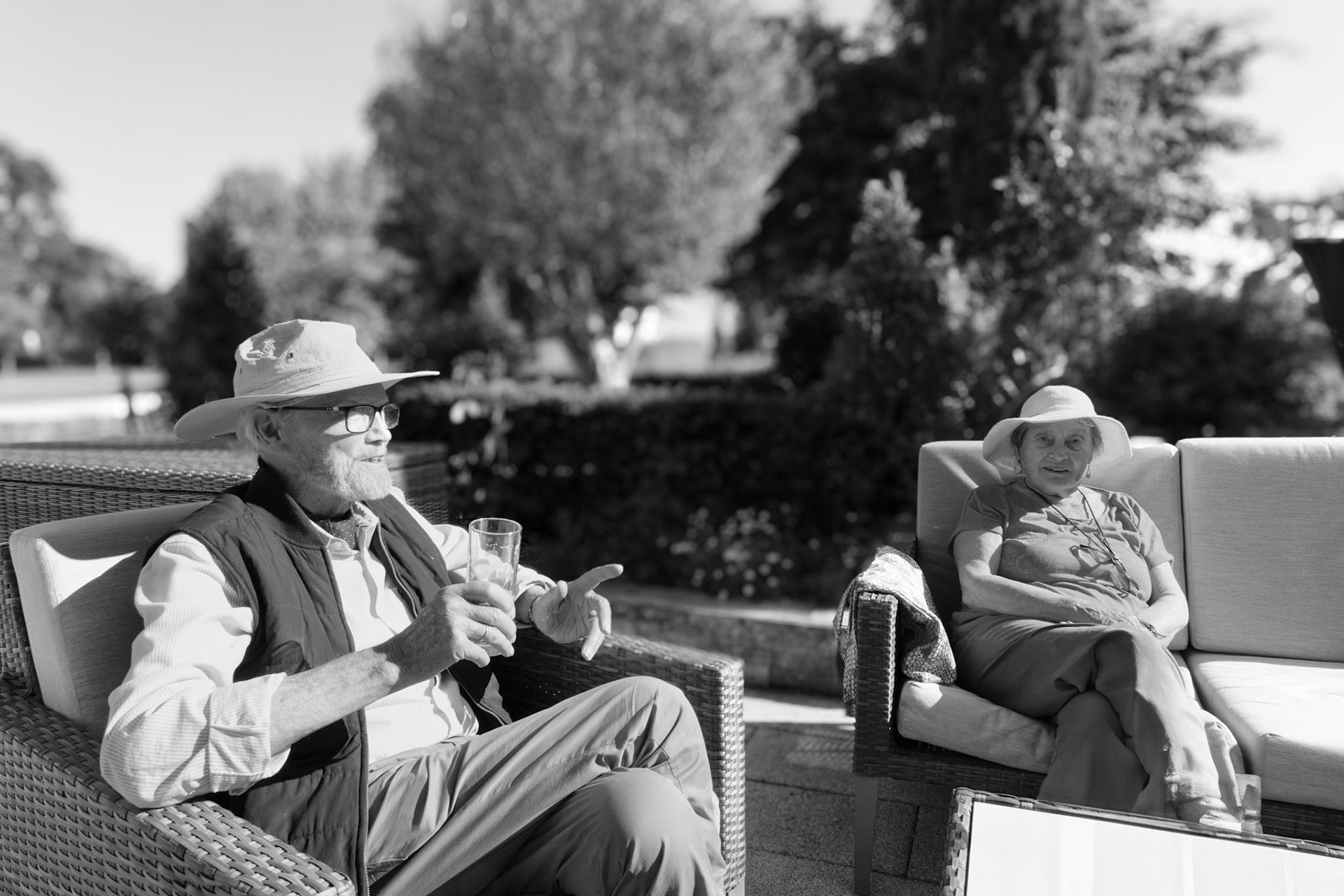 Sunlight, shade, and soft voices—two friends enjoy a relaxed afternoon on the terrace. A study in companionship and comfort, this image distils the serenity of outdoor living at Wadswick Green.