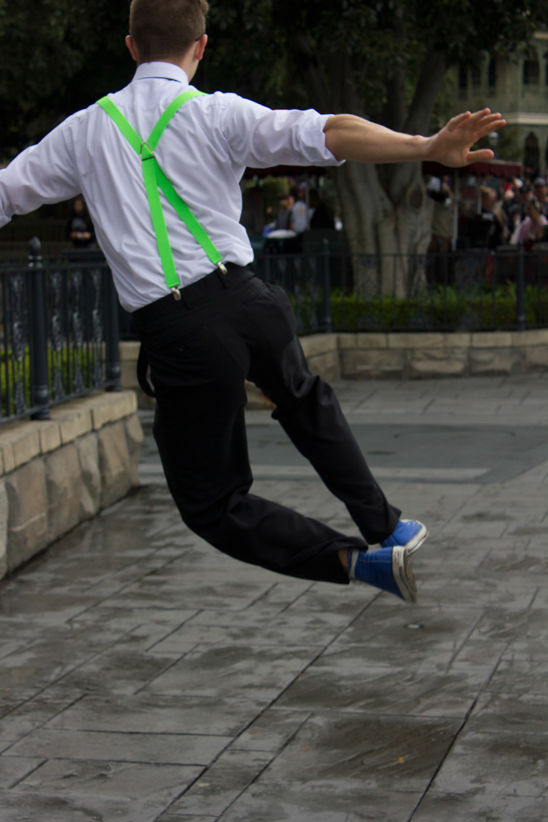 A dapper man is jumping and clicking his heals together in excitement of retro fashion
