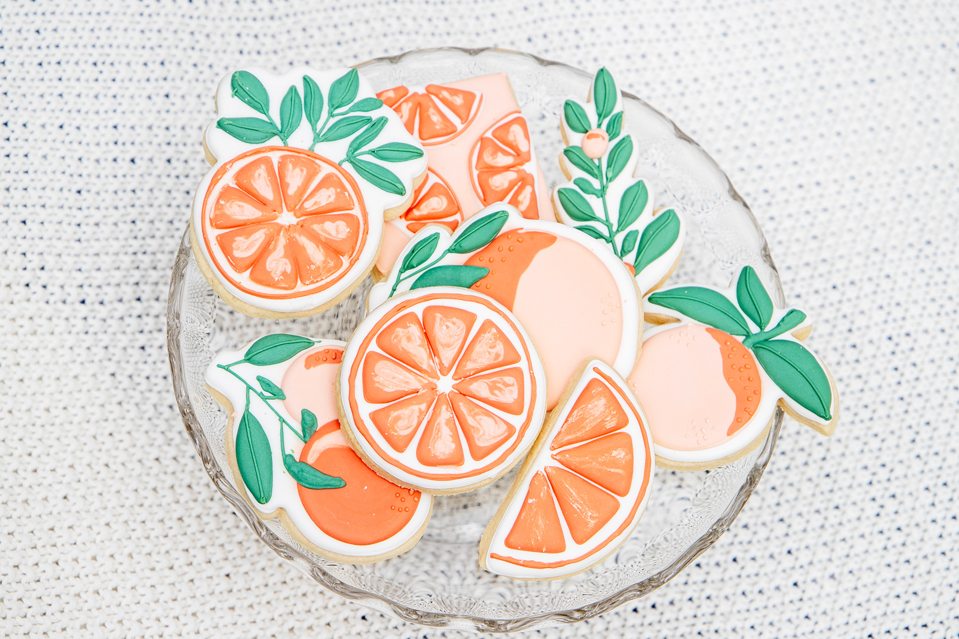 A product photo of cookies that are decorated like oranges.