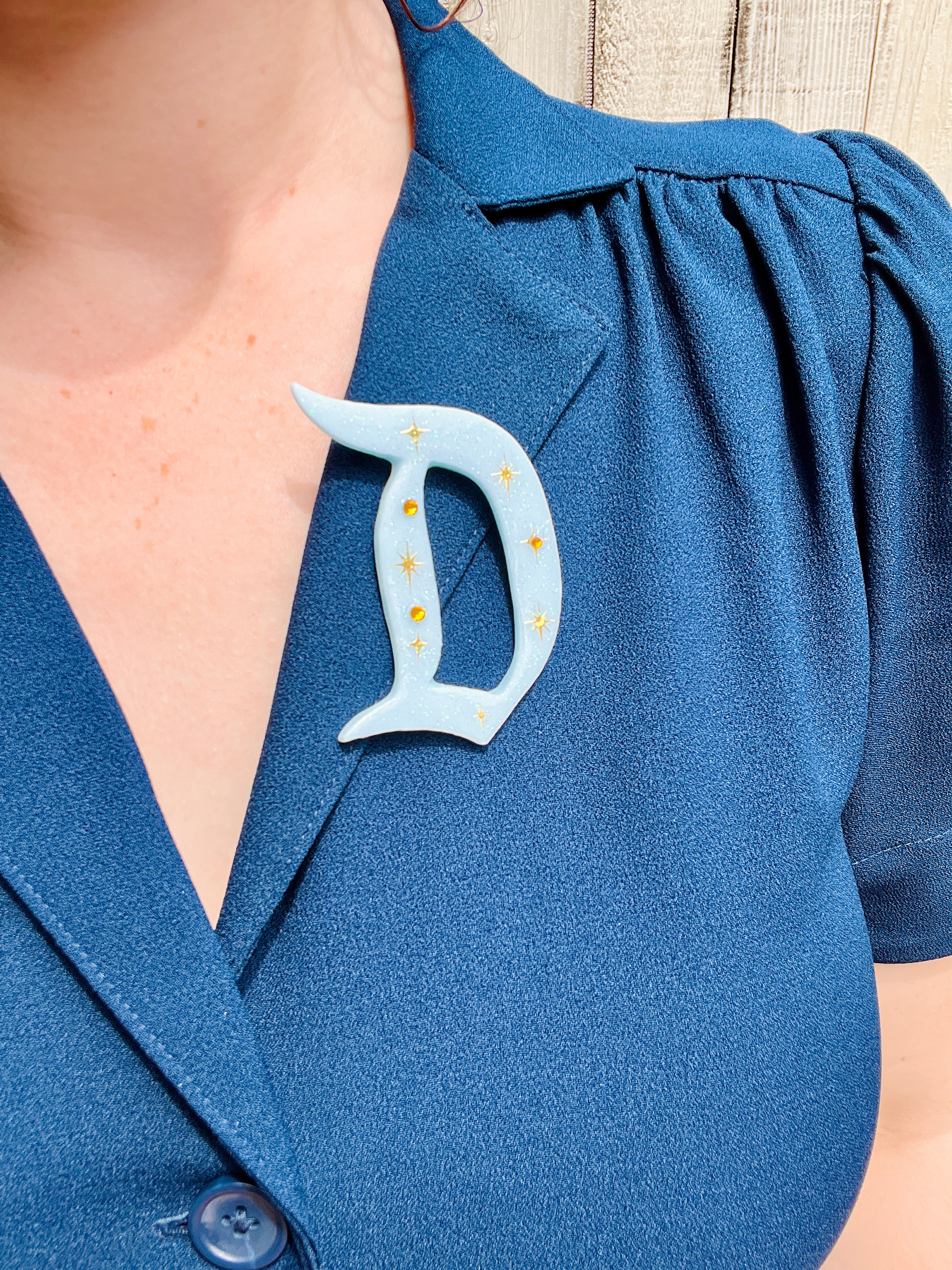 Picture of Kaytie dressed in her 1950's styled outfit Disney bounding as the Disneyland Hotel. Image of the pin she bought from the Star Brite Motel booth!