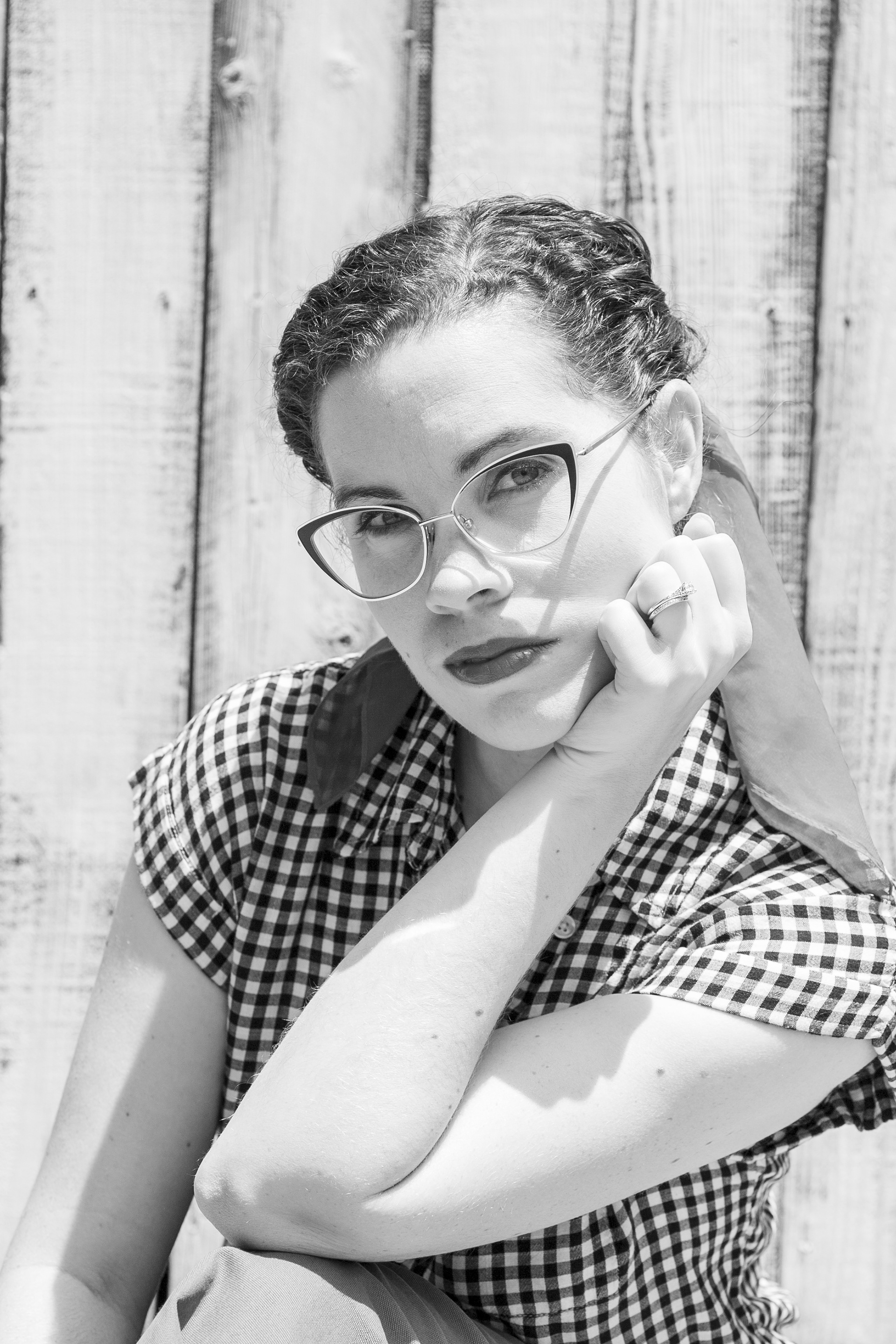 Kaytie in a self rockabilly portrait wearing cat eyed glasses and a retro blouse.