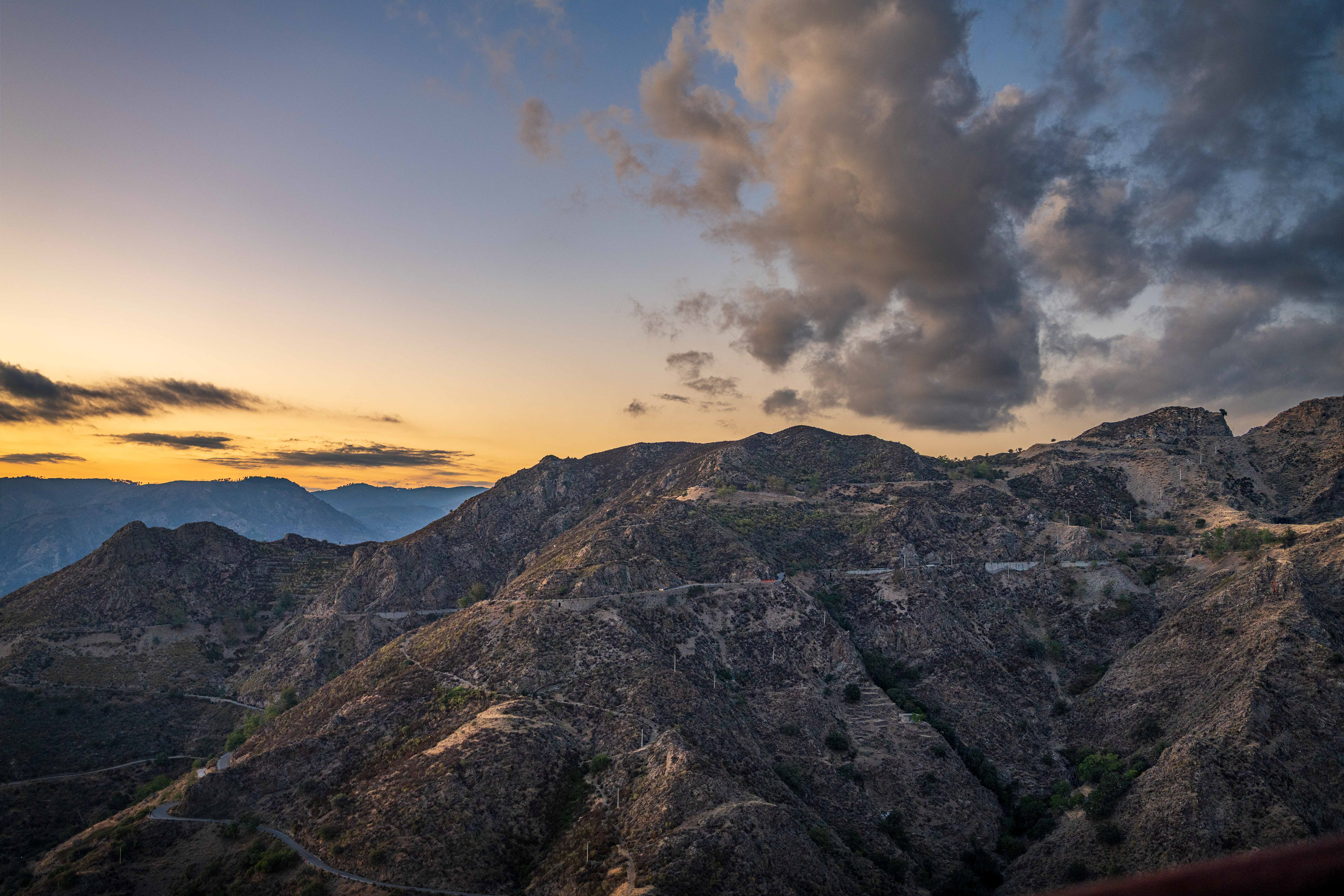 A mountain with a sunset behind it.