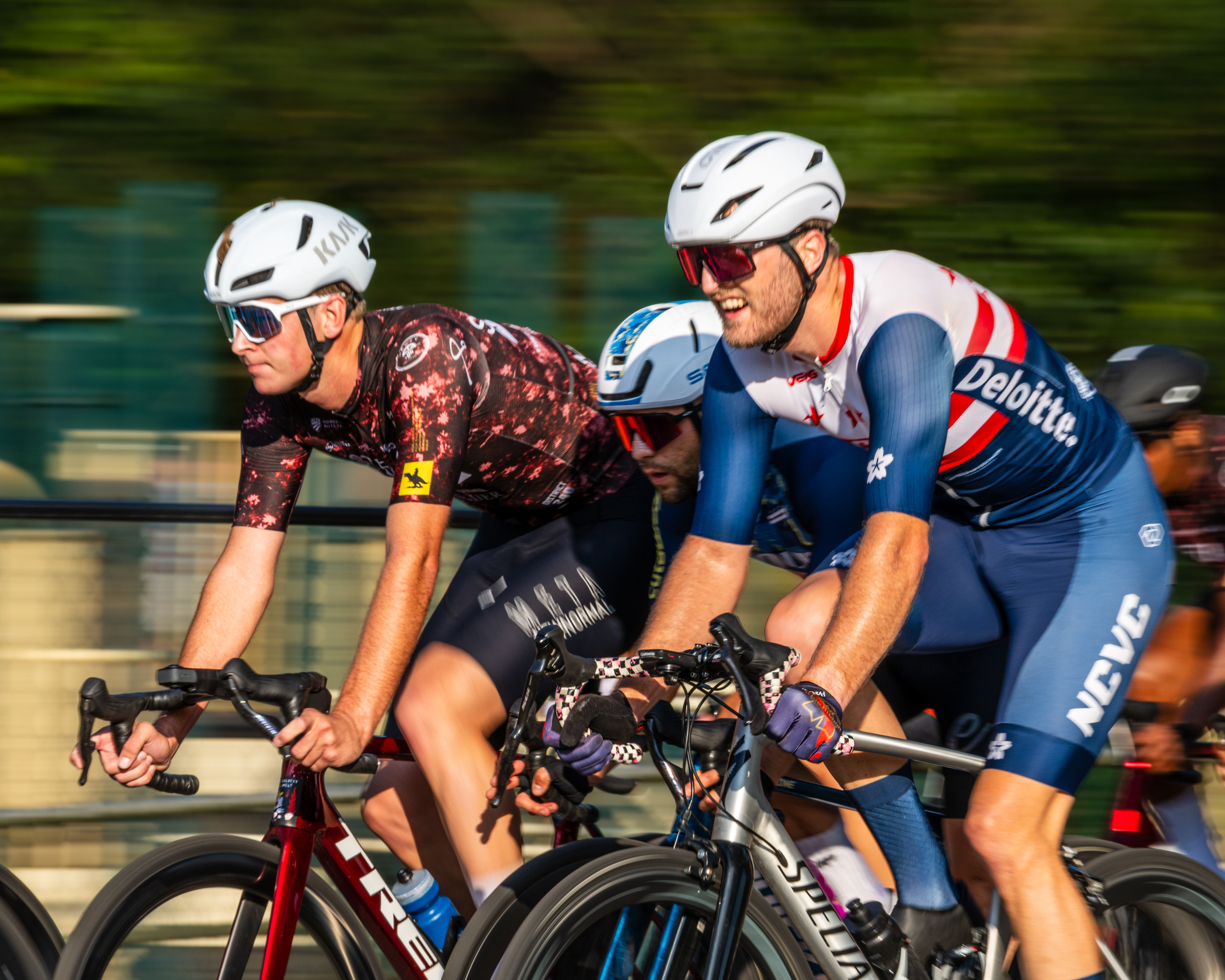 Three men racing bicycles.