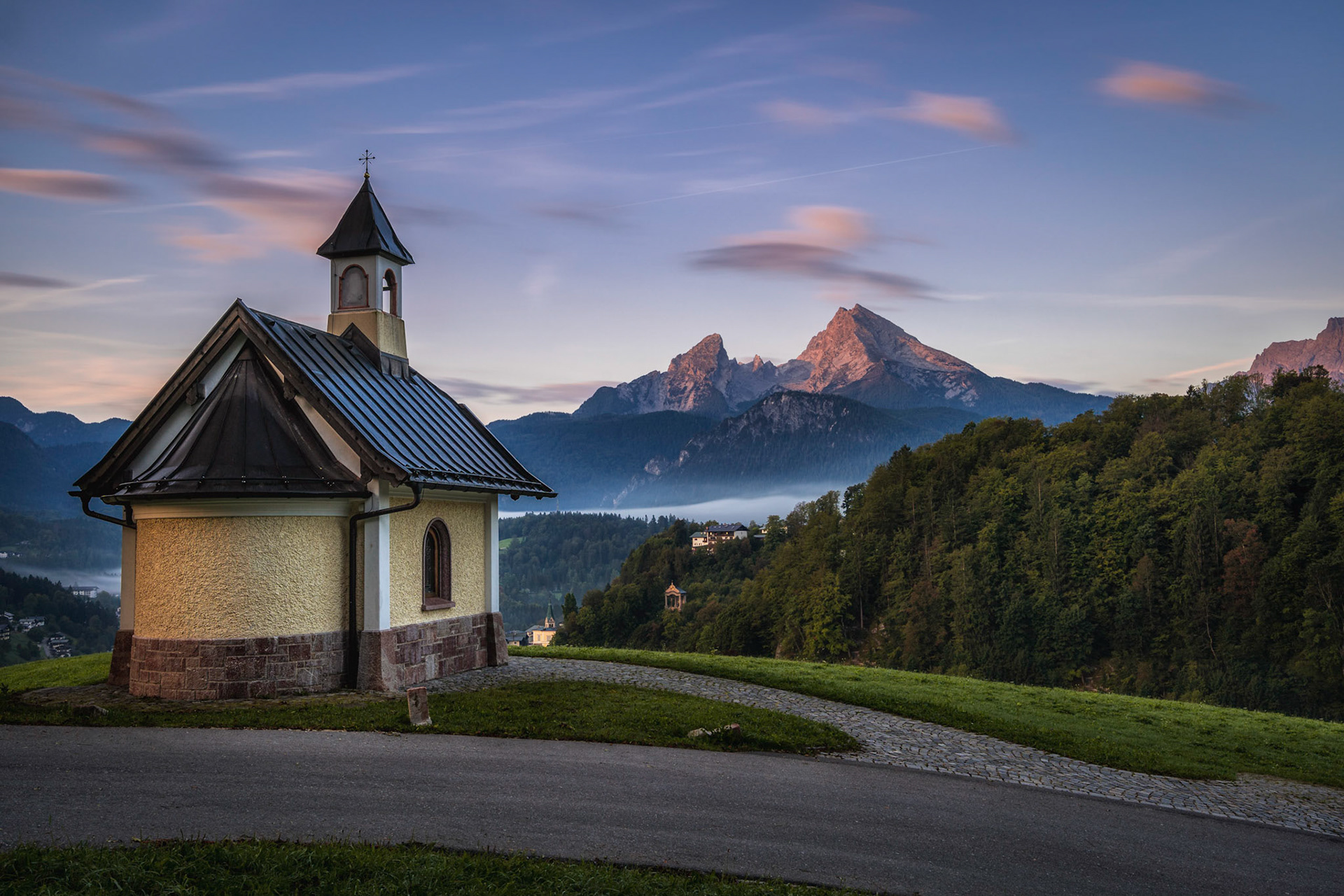 Im Hintergrund strahlt der Sonnenaufgang den Watzmann an.