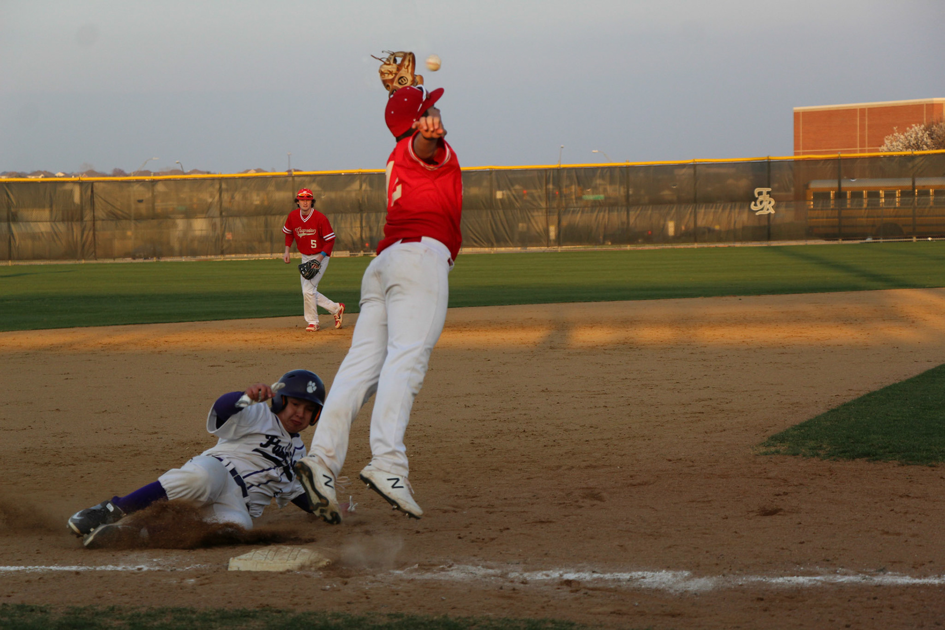 FOREVER ANTICIPATION- Grapevine High School’s player, DJ Catalano, stretches to make a crucial catch just moments before a rivalry Colleyville Heritage Panther can reach the base. Despite the defensive effort, the Mustangs fell short in a 4-0 loss. By Alaina Jones