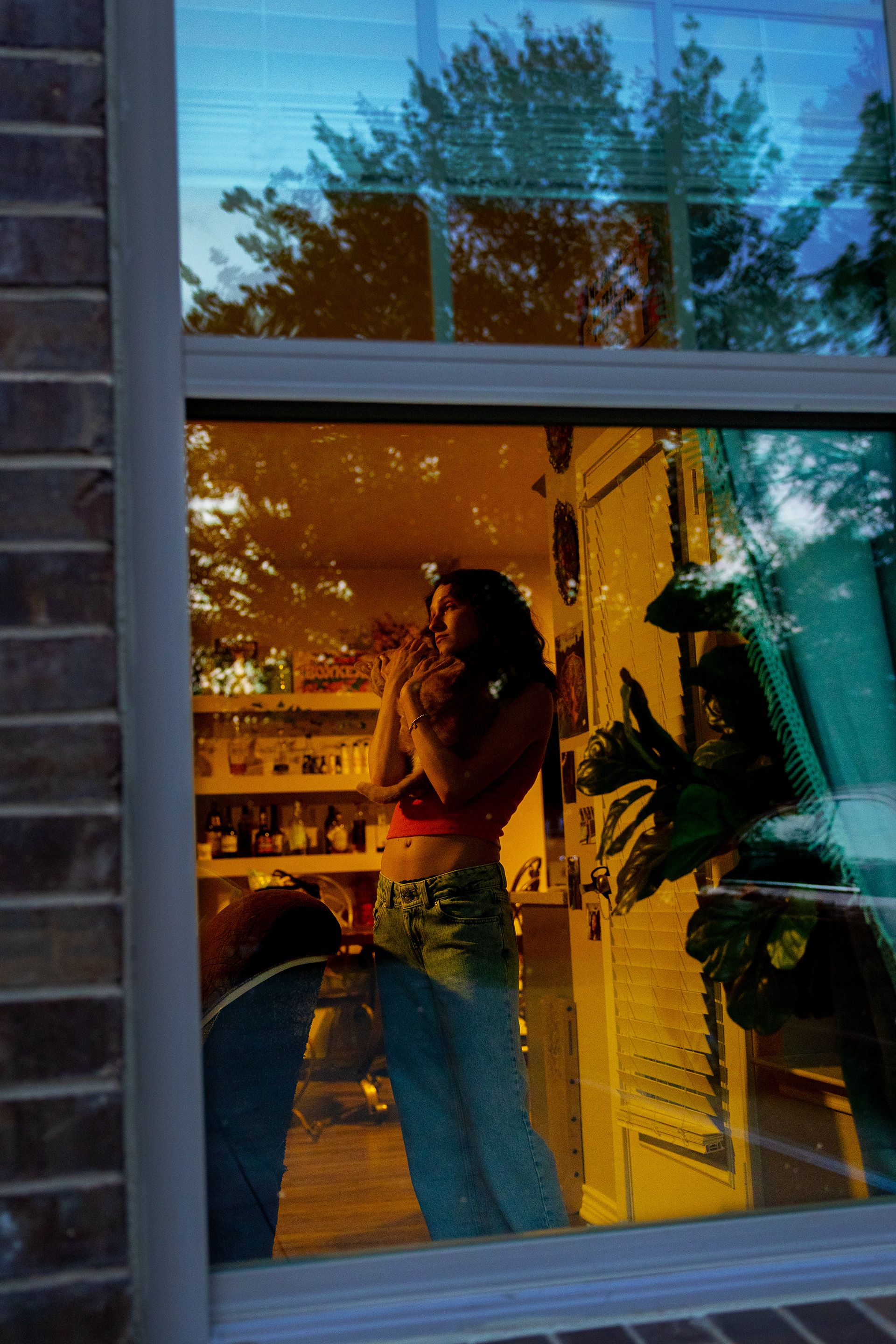 Denton, Texas May 6, 2024   Reed holds her beloved cat, Beans, after a long day at her home.   “It is hard to not be graduating this semester. I feel like I pushed all of my life plans on hold, but I think everything happens for a reason and maybe I just need this time period to grow and appreciate where I currently am and the meaningful connections I have made along my journey.”  By Alaina Jones 