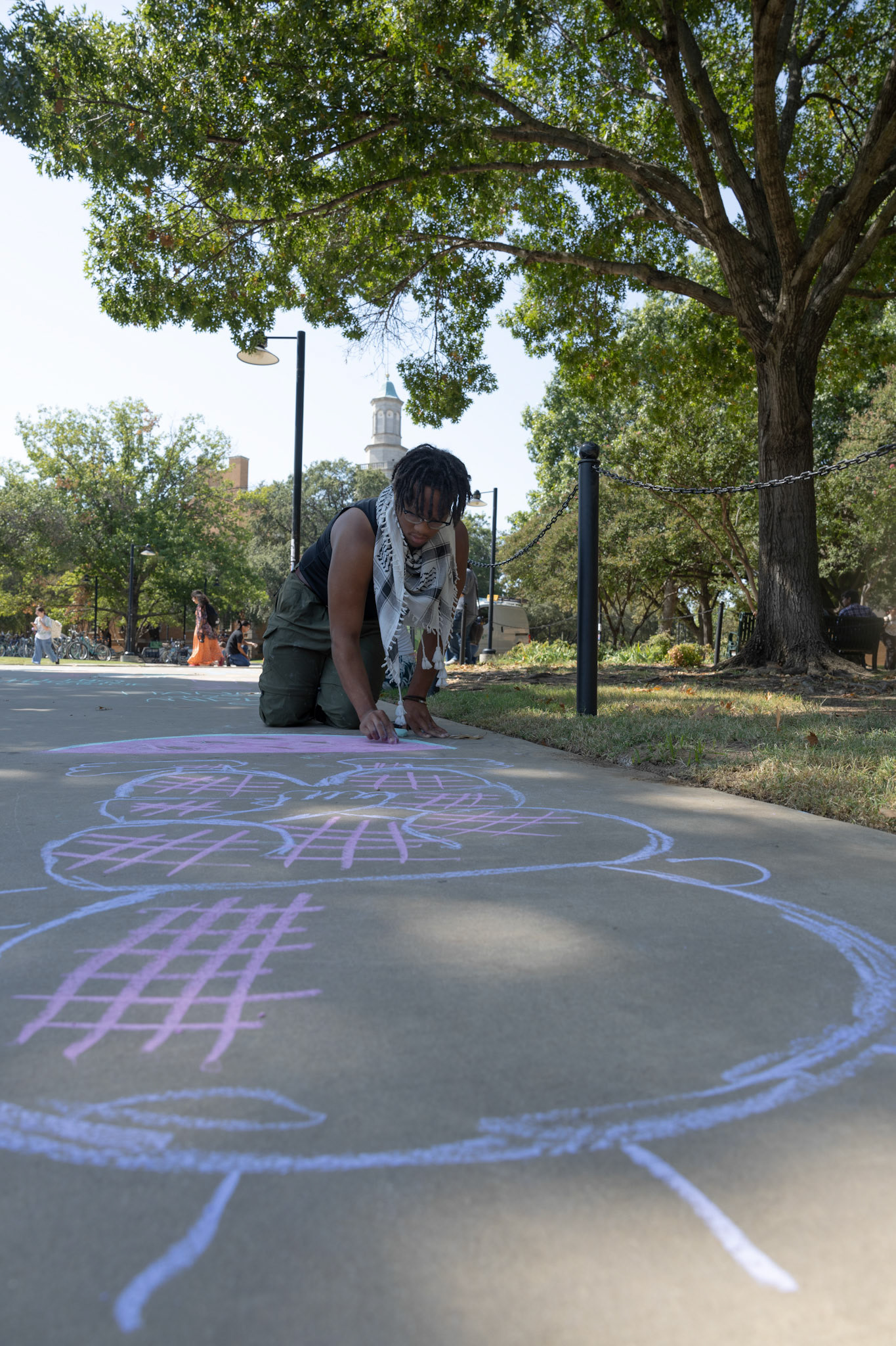 HANDALA- Senior Ty Scott drawas Palestinian child, Handala during the 'Week of Rage' Chalk the block on Oct. 8 2024. Photo By Alaina Jones