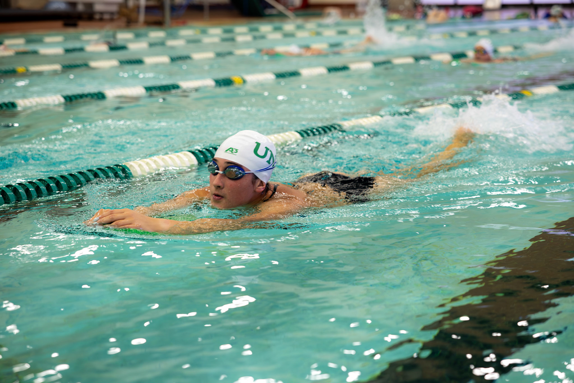 Breaking the Surface BREAKING THE SURFACE- Gabi Somoza paddles while using a kickboard to strengthen her leg muscles and improve her overall technique. By Alaina Jones