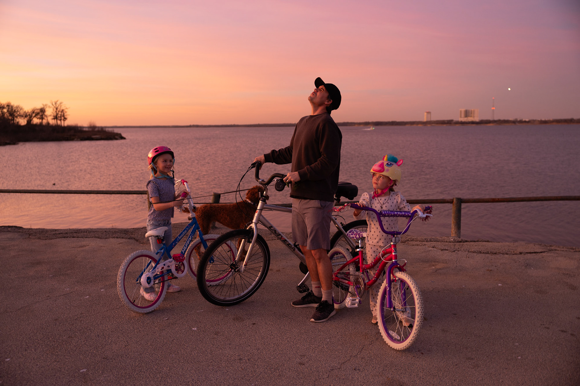 HOWLING TO GO HOME- After riding bikes around Grapevine Lake, Trevor Ashlock, howls at the sunset on February 2, 2025, in hopes to make his daughters laugh. “I love riding bikes with my daughters and dog because it is a way for us to spend time together and have fun after I get off work,” Ashlock said. Photo by Alaina Jones 